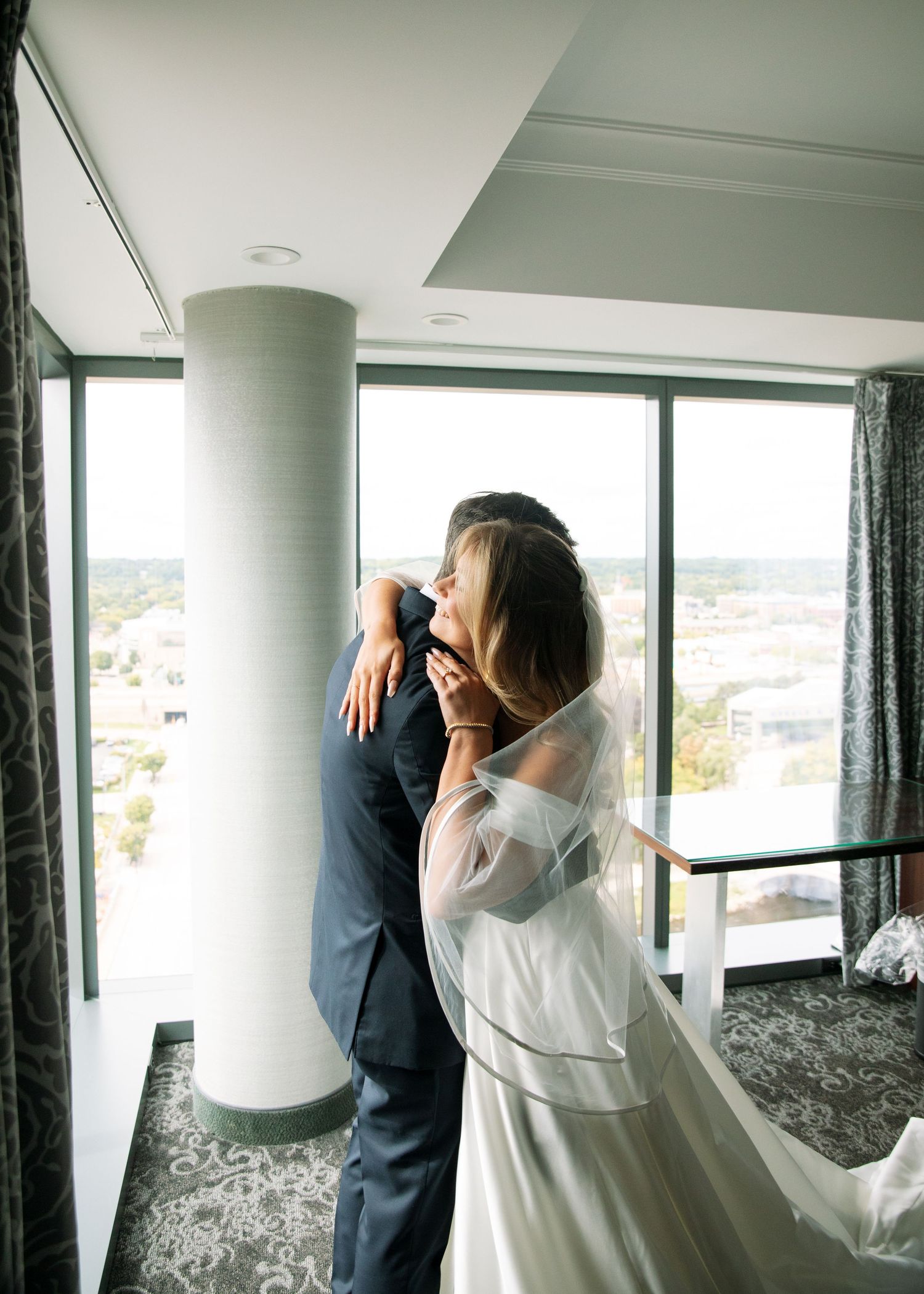 Wedding photography session by large windows with scenic views.