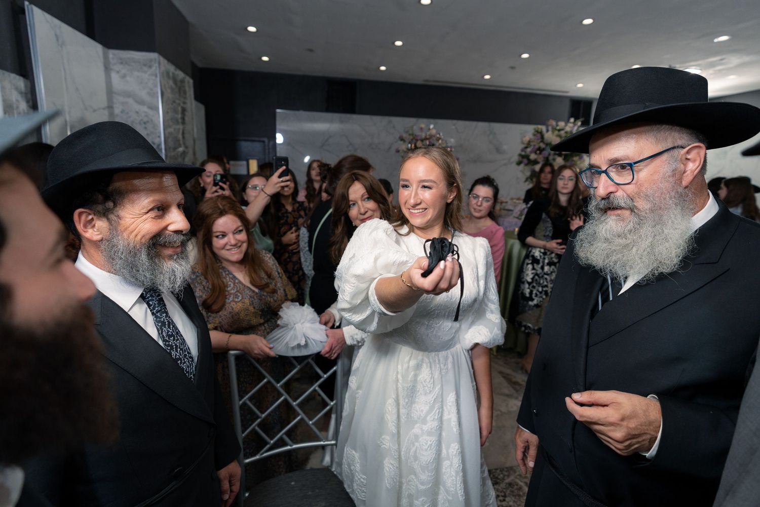 A joyous indoor wedding celebration with guests in formal attire.