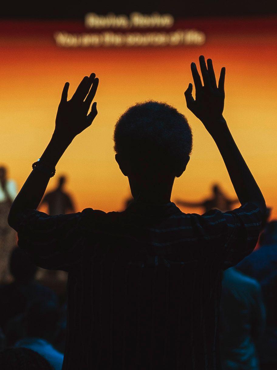 An old man worshipping God with his hands up high.
