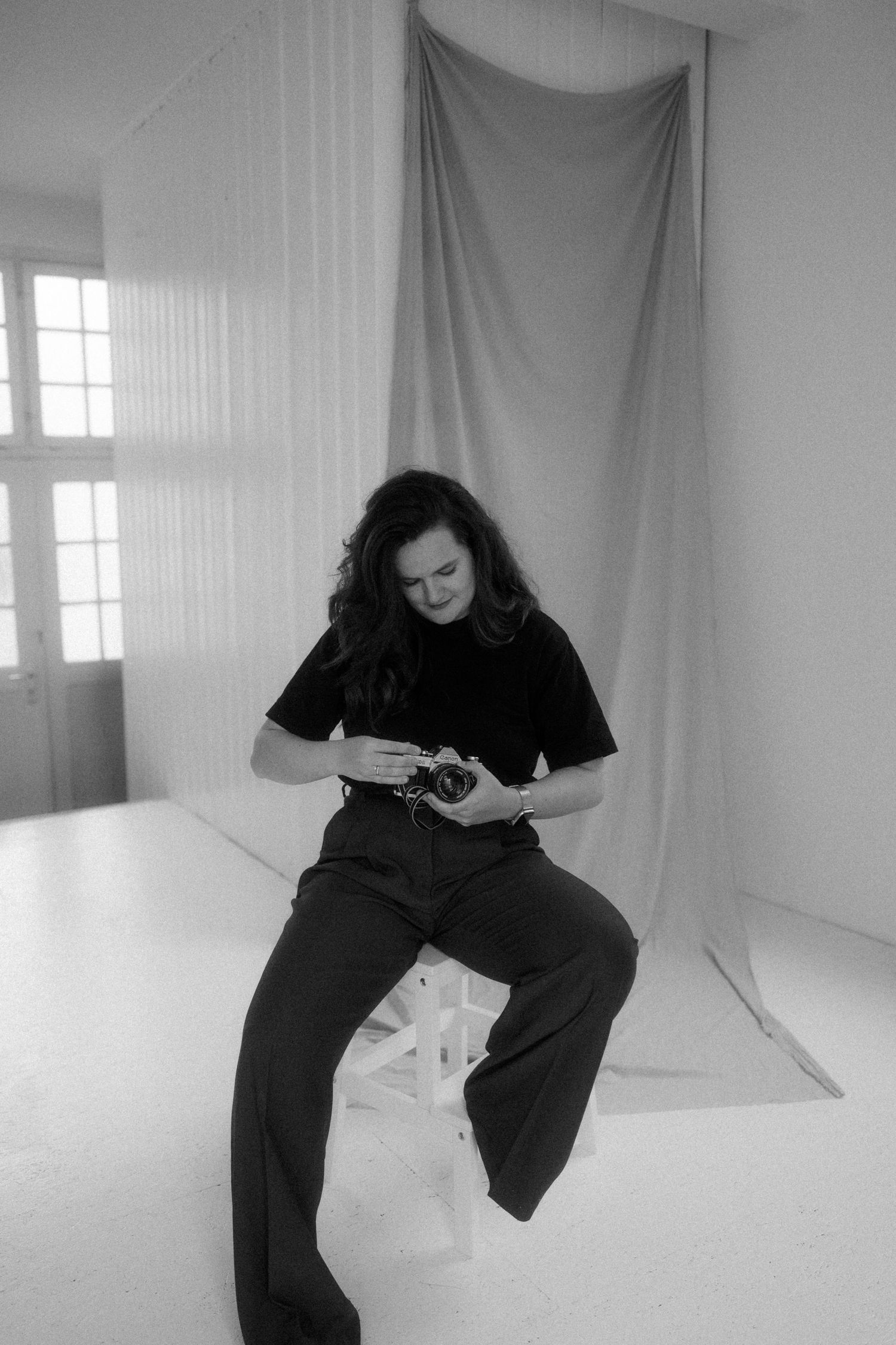 Black and white studio photos showing artistic movement poses in a minimalist white space.