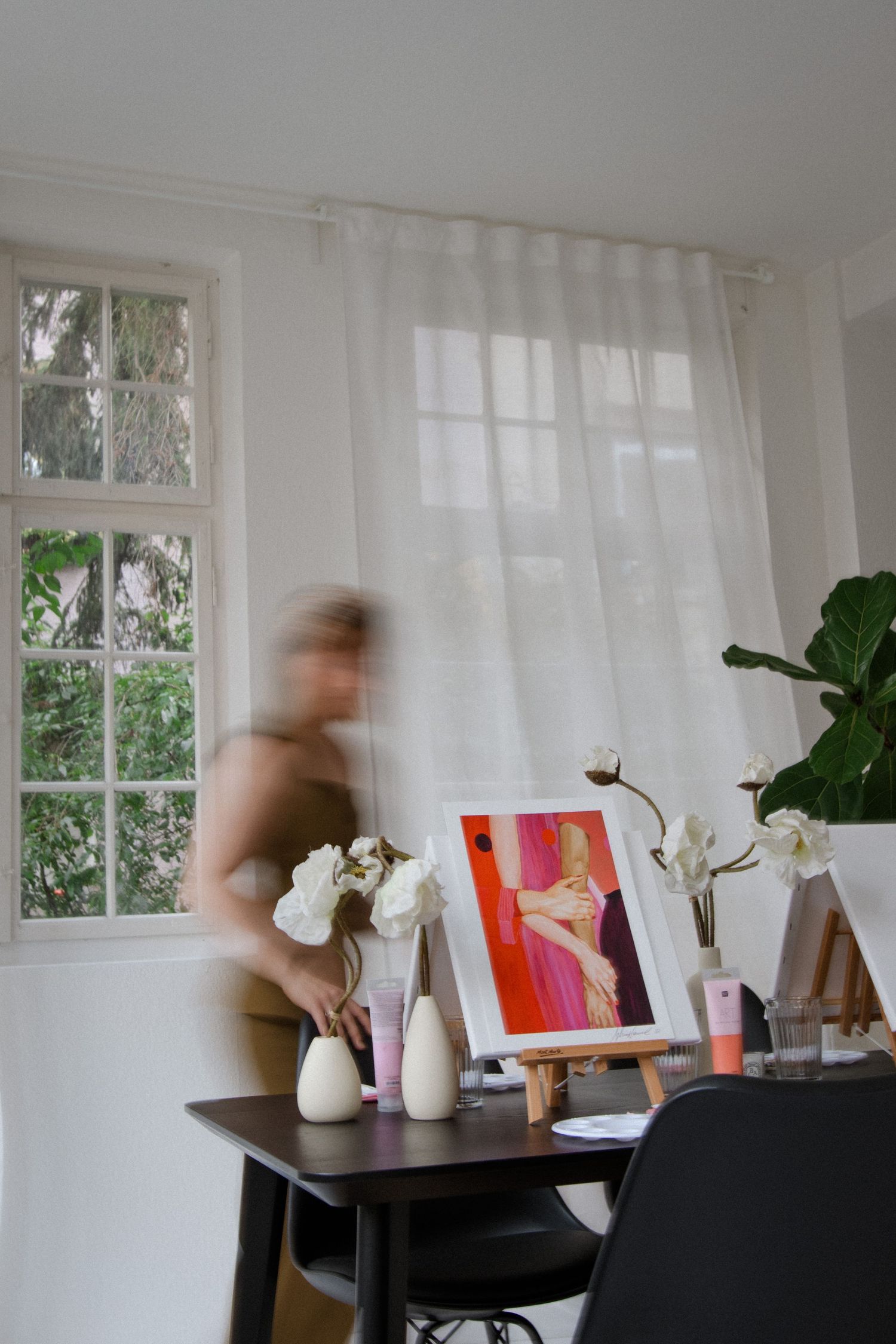 Motion blur photography in a bright white room with furniture and decorative vases.