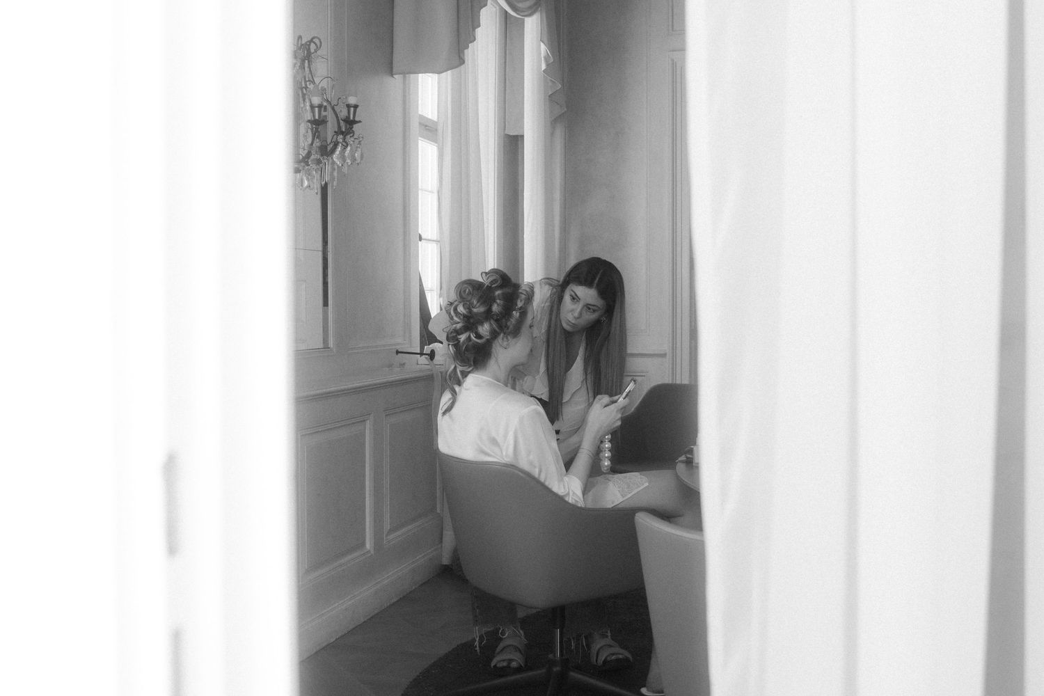 Bright white room with window light streaming in during wedding preparations.