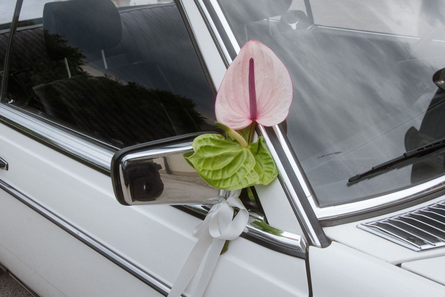 Wedding decorations and flowers adorning a classic car.