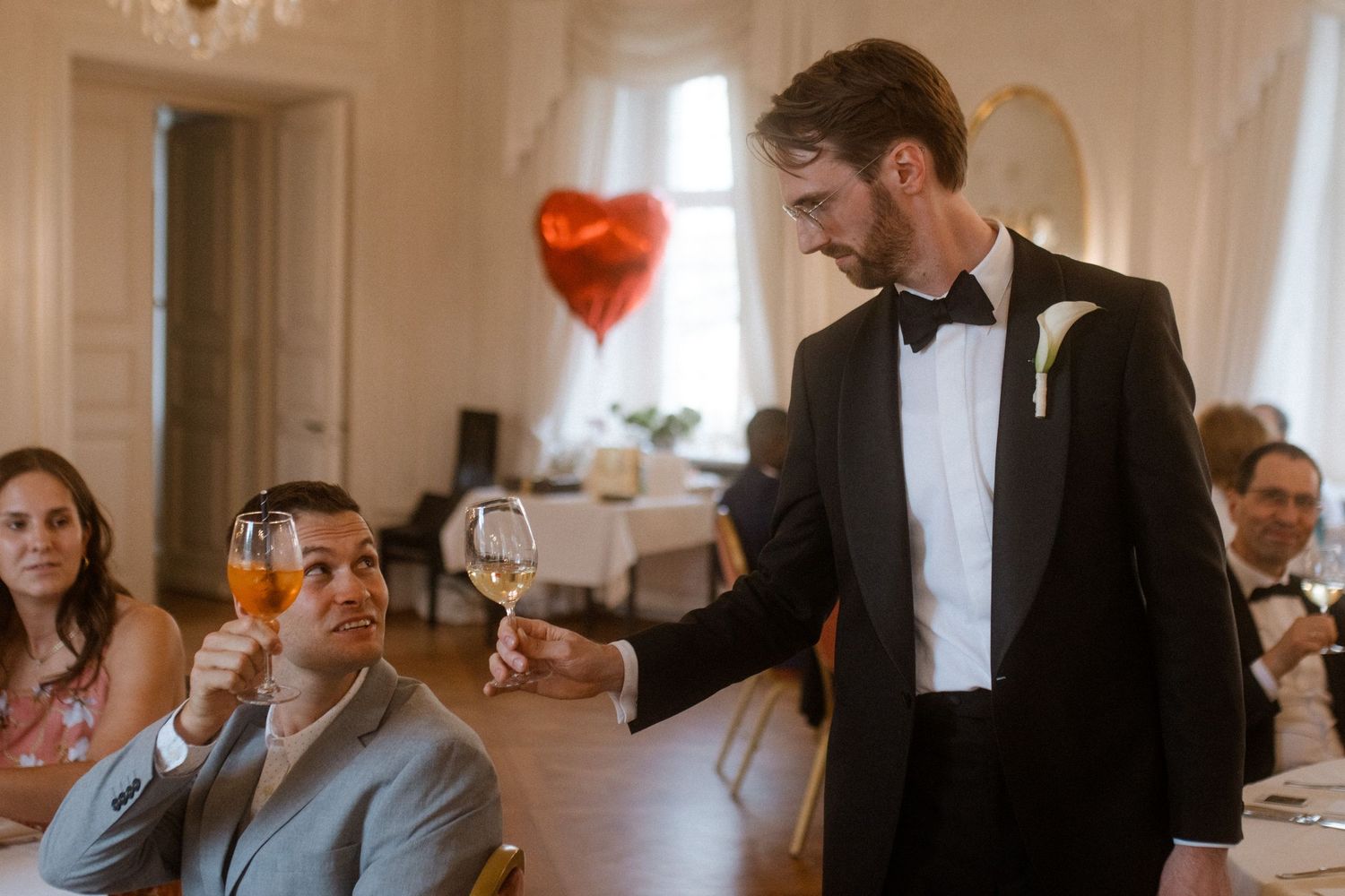Wedding guests enjoying conversation at formal reception tables.