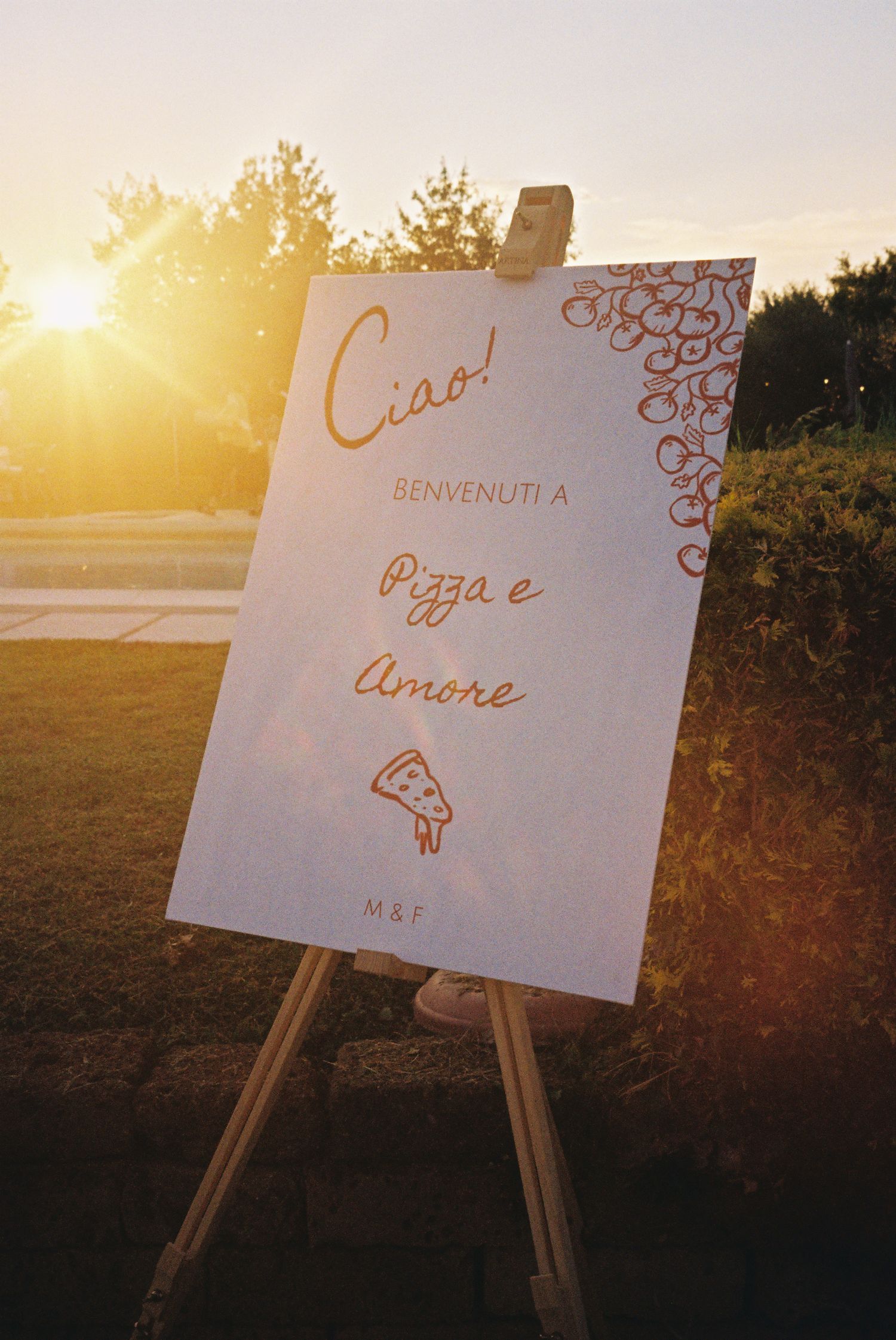 Wedding welcome signs on easels at sunset with decorative calligraphy.