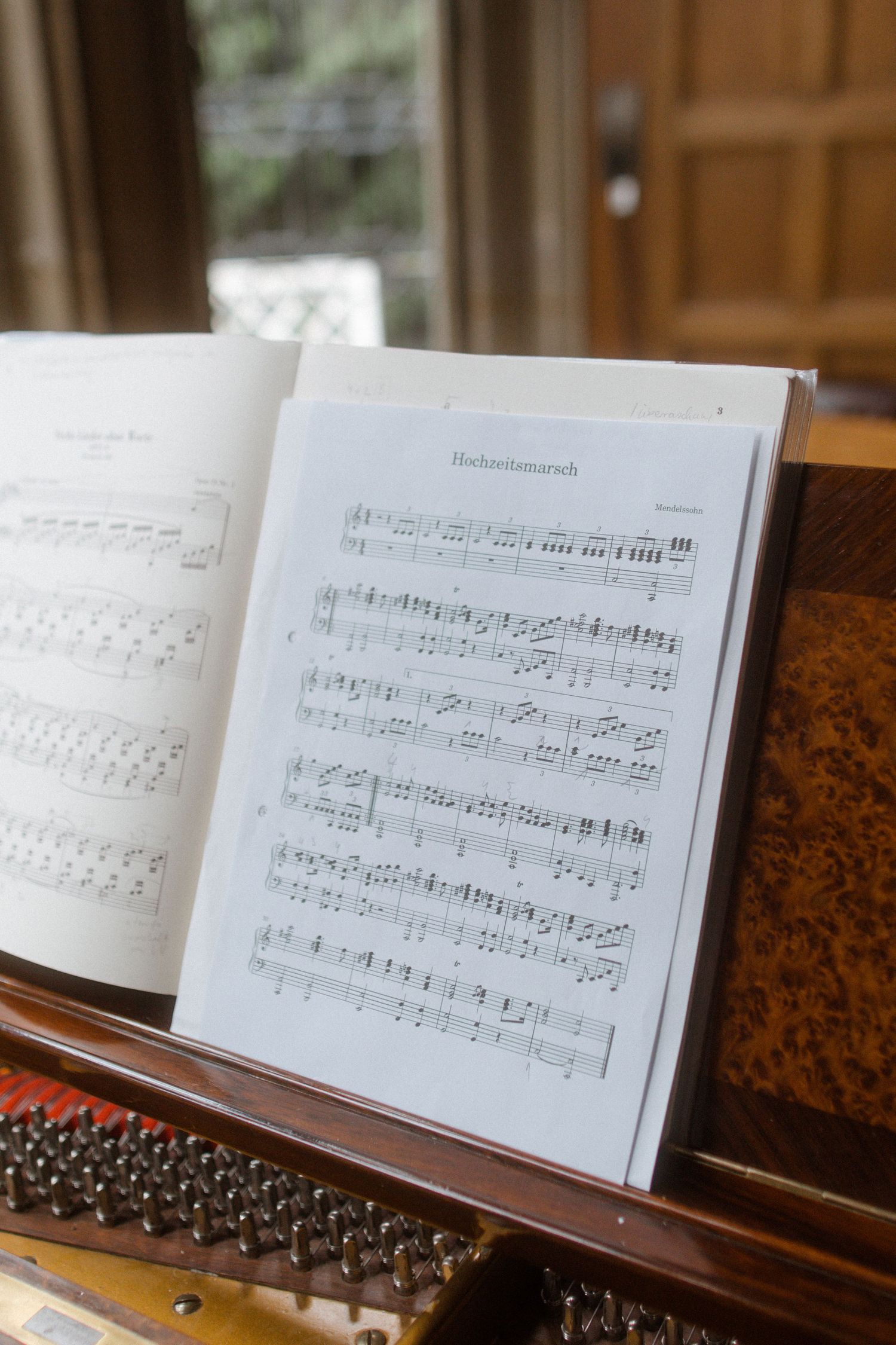 Sheet music displayed on a wooden piano with natural lighting.