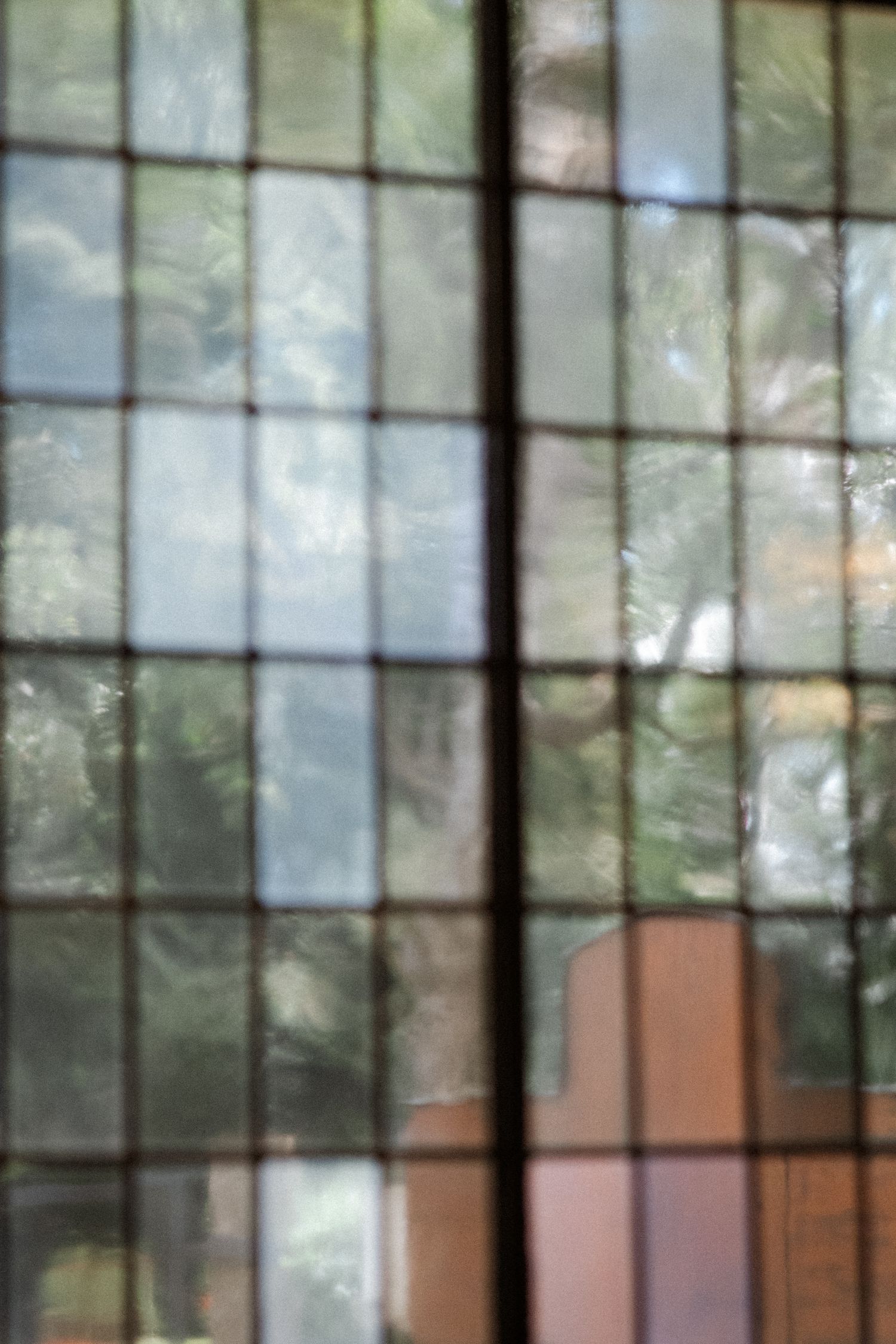 Abstract view through gridded church window with soft natural light filtering through.