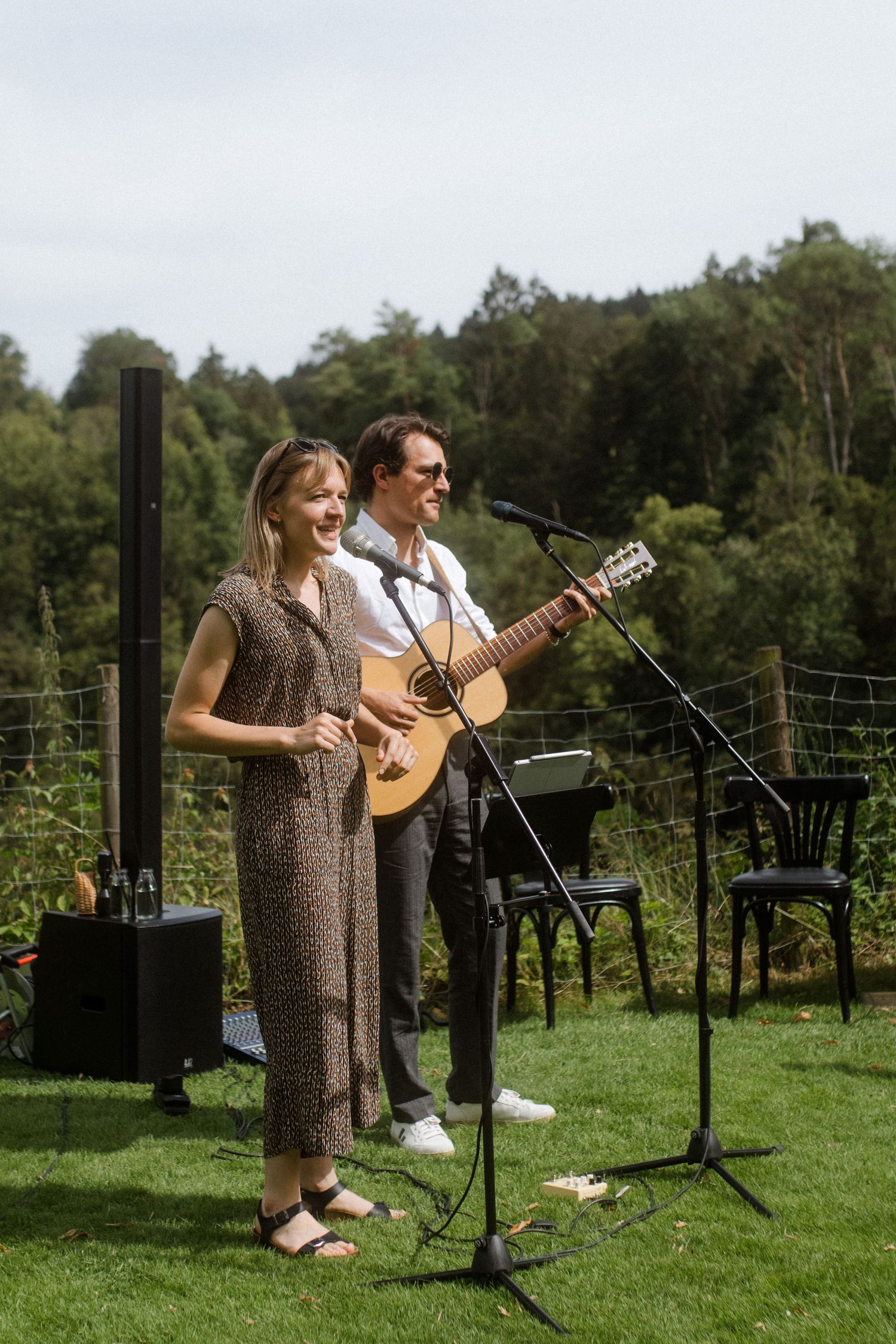 Musicians perform live acoustic music at an outdoor garden wedding.