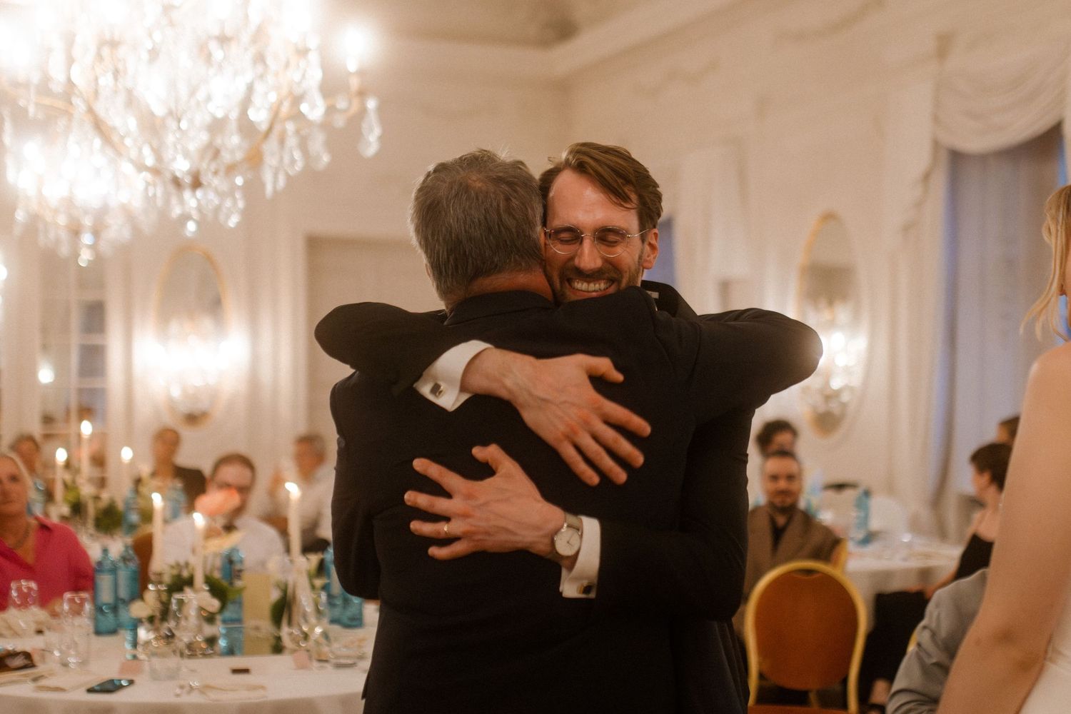 Joyful embraces and celebrations at an elegant wedding reception in a grand ballroom.