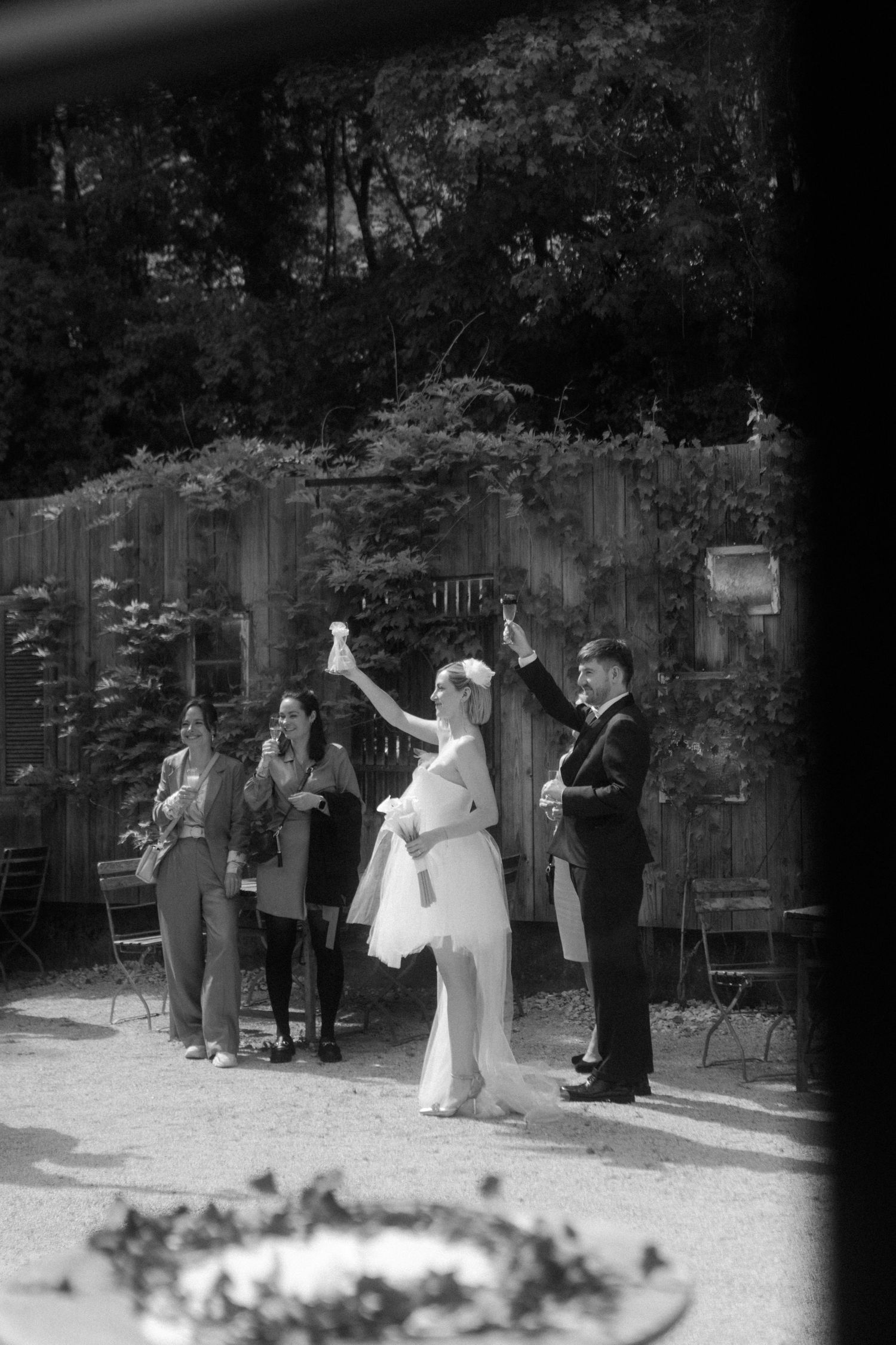 Black and white photo of wedding guests celebrating outdoors.