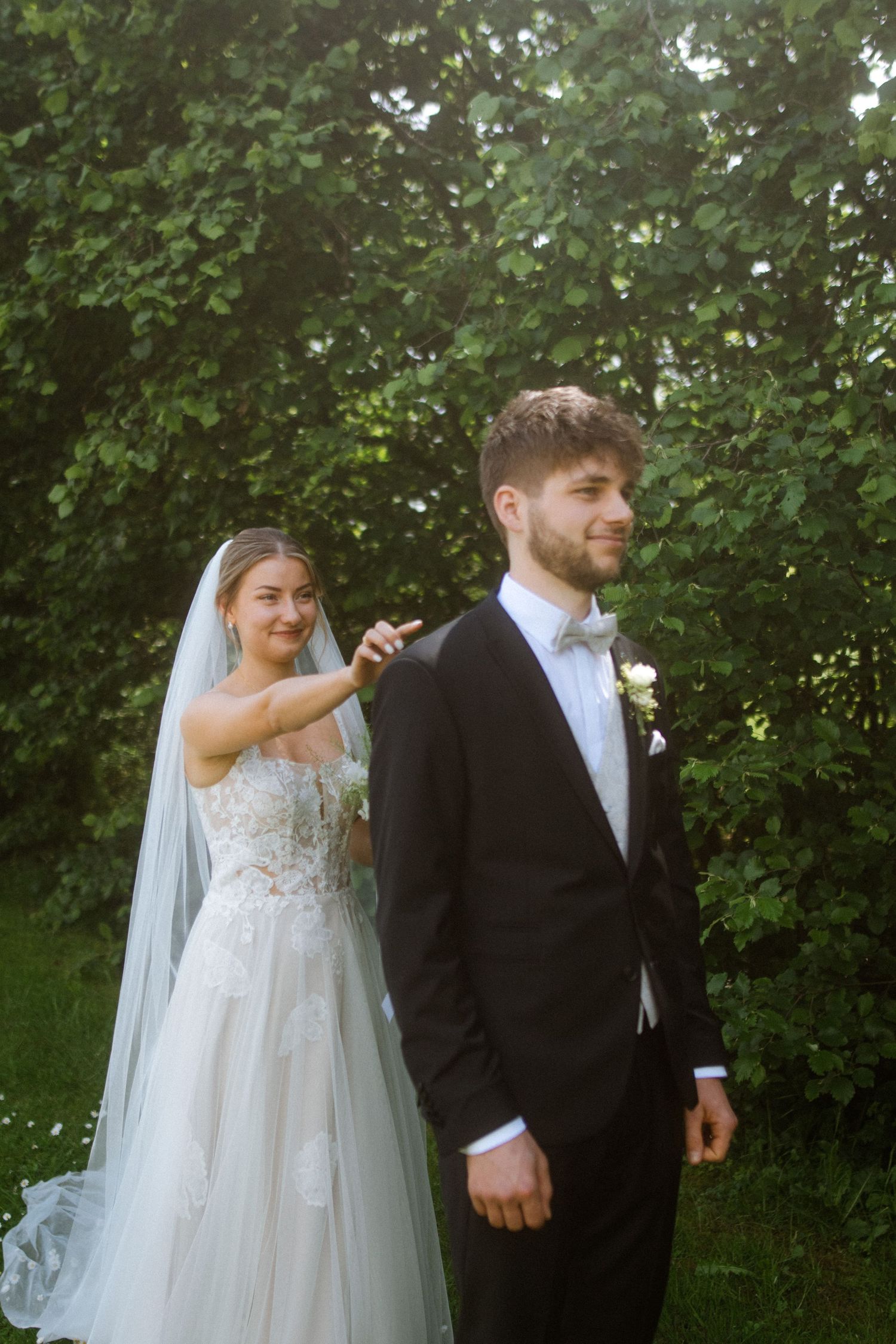 Wedding couple shares a candid moment during their first look in a garden setting.