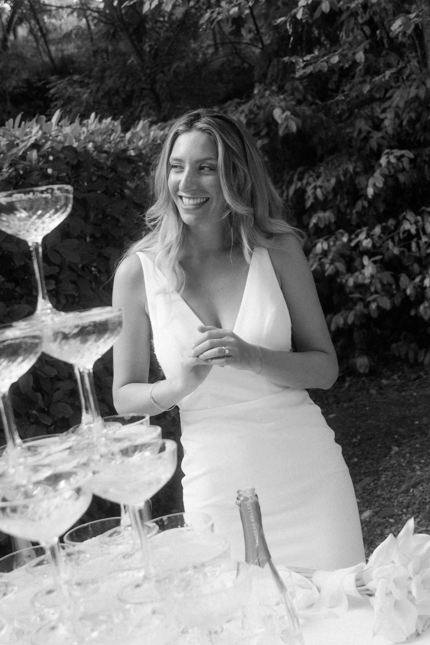Close-up shots of champagne being poured into crystal glasses at an outdoor wedding.