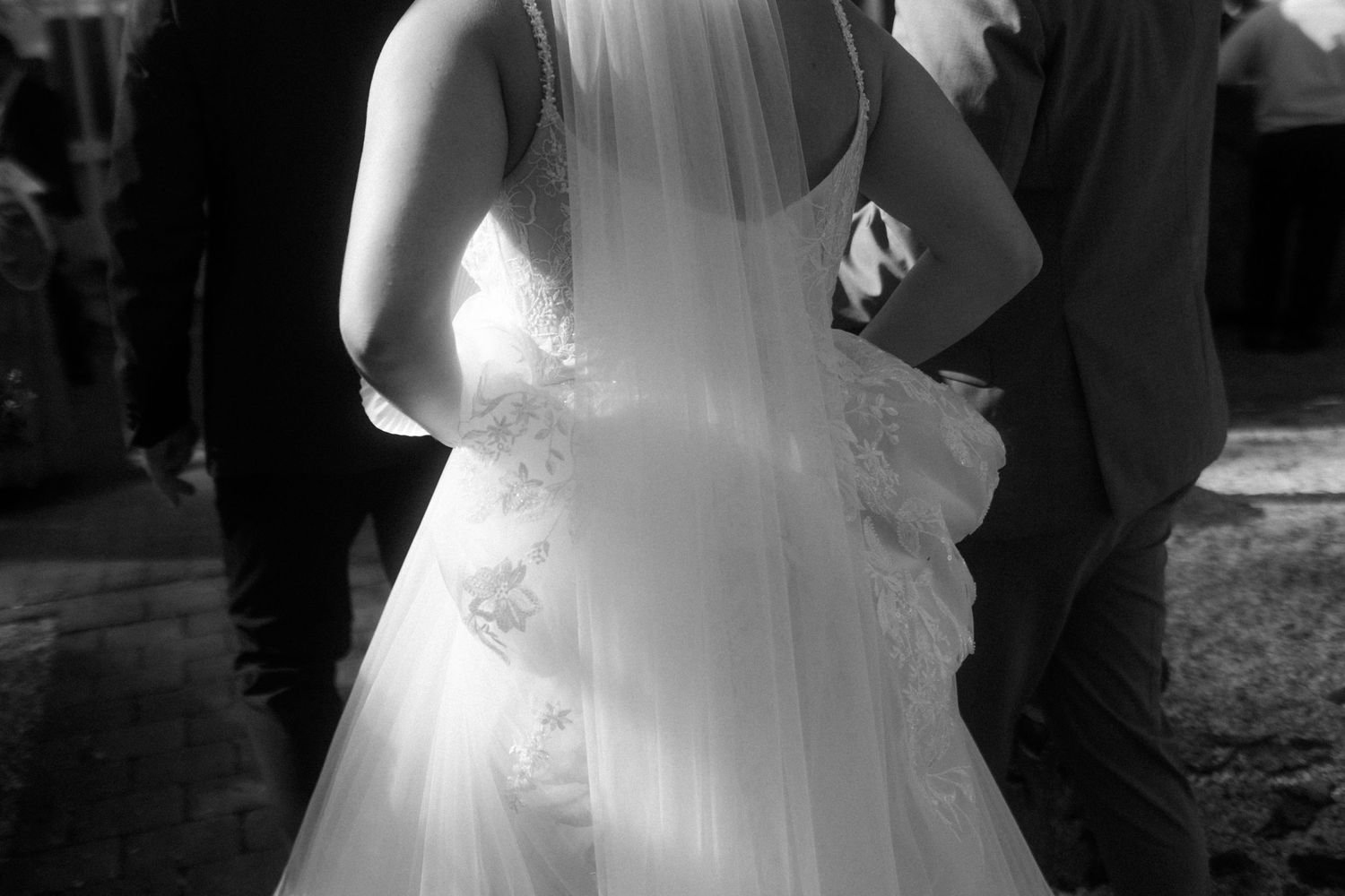Close-up detail of a white wedding dress with lace and tulle fabric.