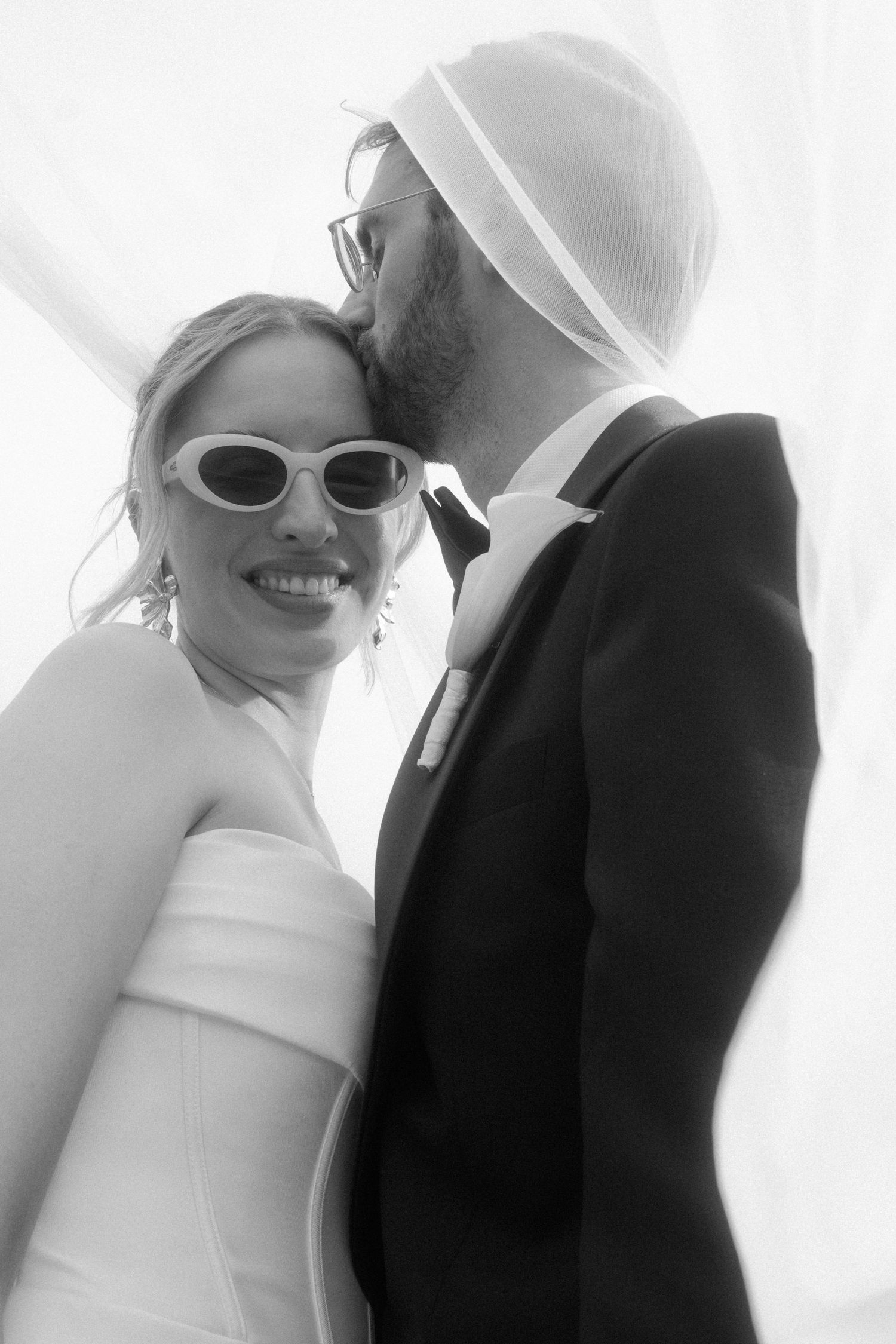 High-key wedding portraits with sunglasses and bright smiles.