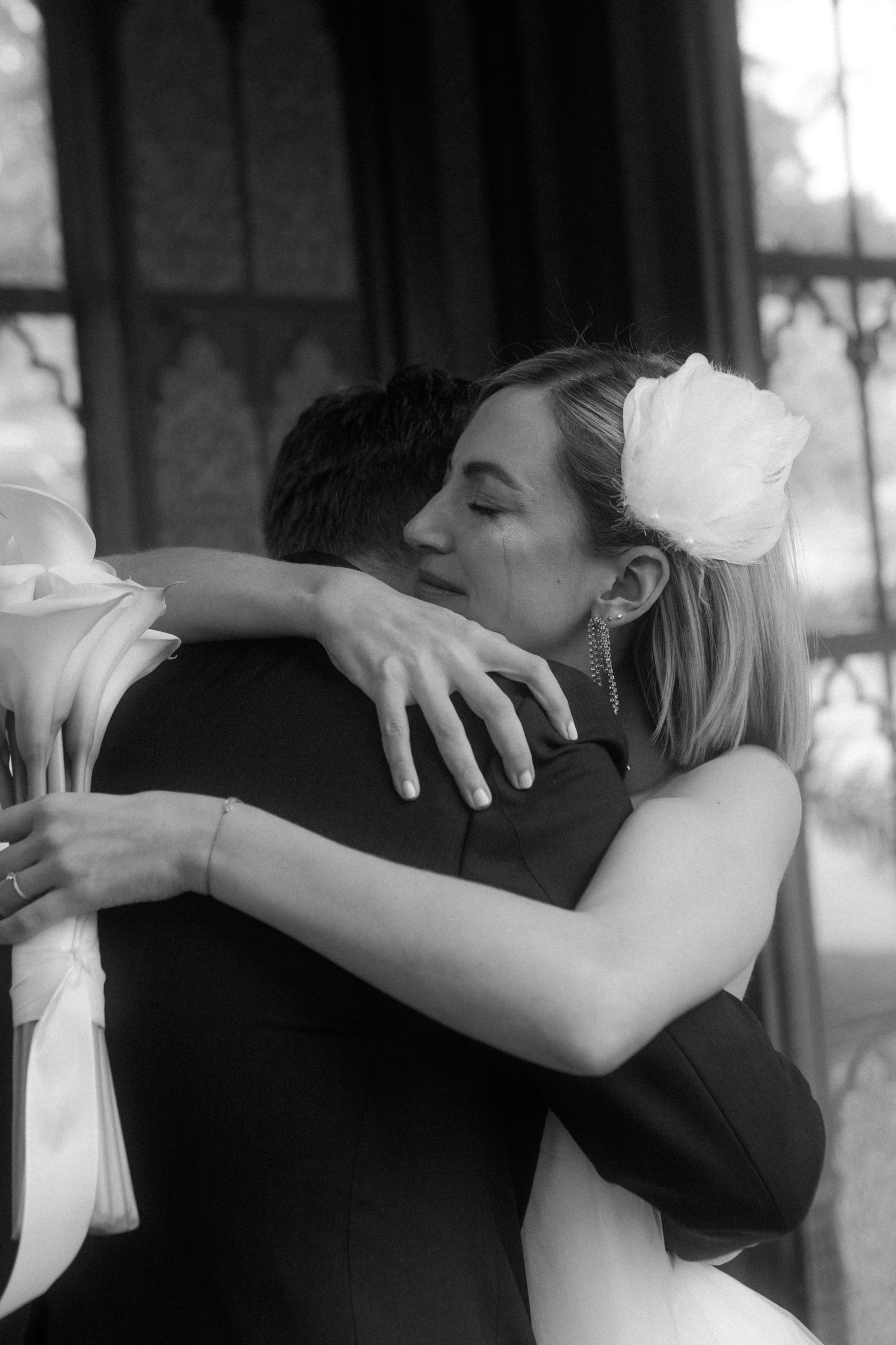 A tender embrace between newlyweds captured in black and white at their wedding celebration.