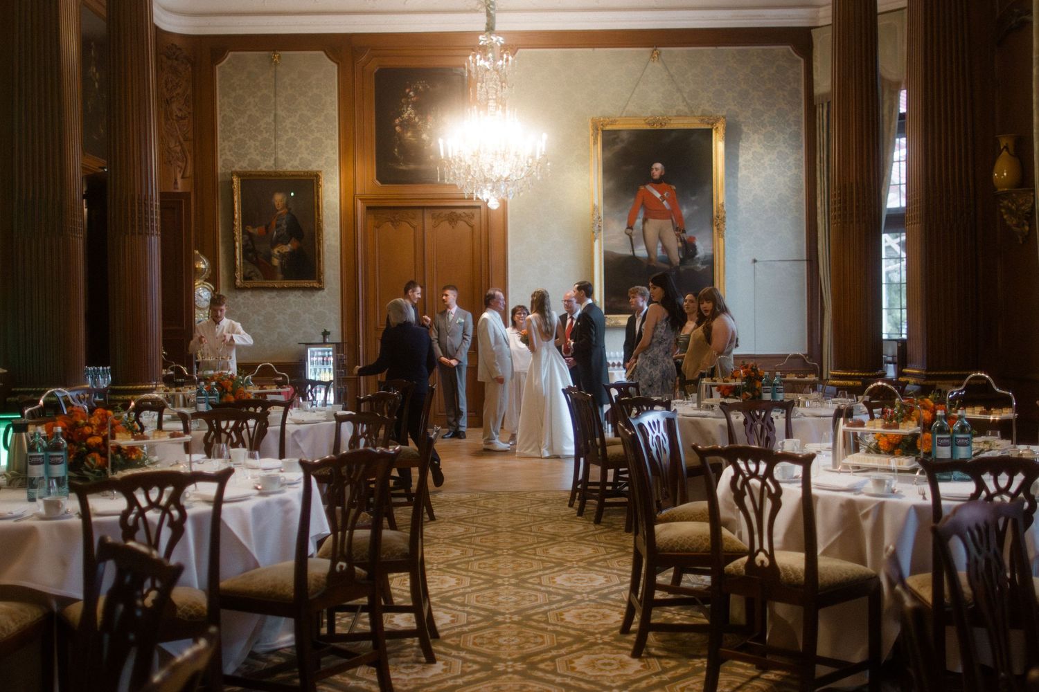 Elegant wedding reception hall with chandeliers and formal table settings.