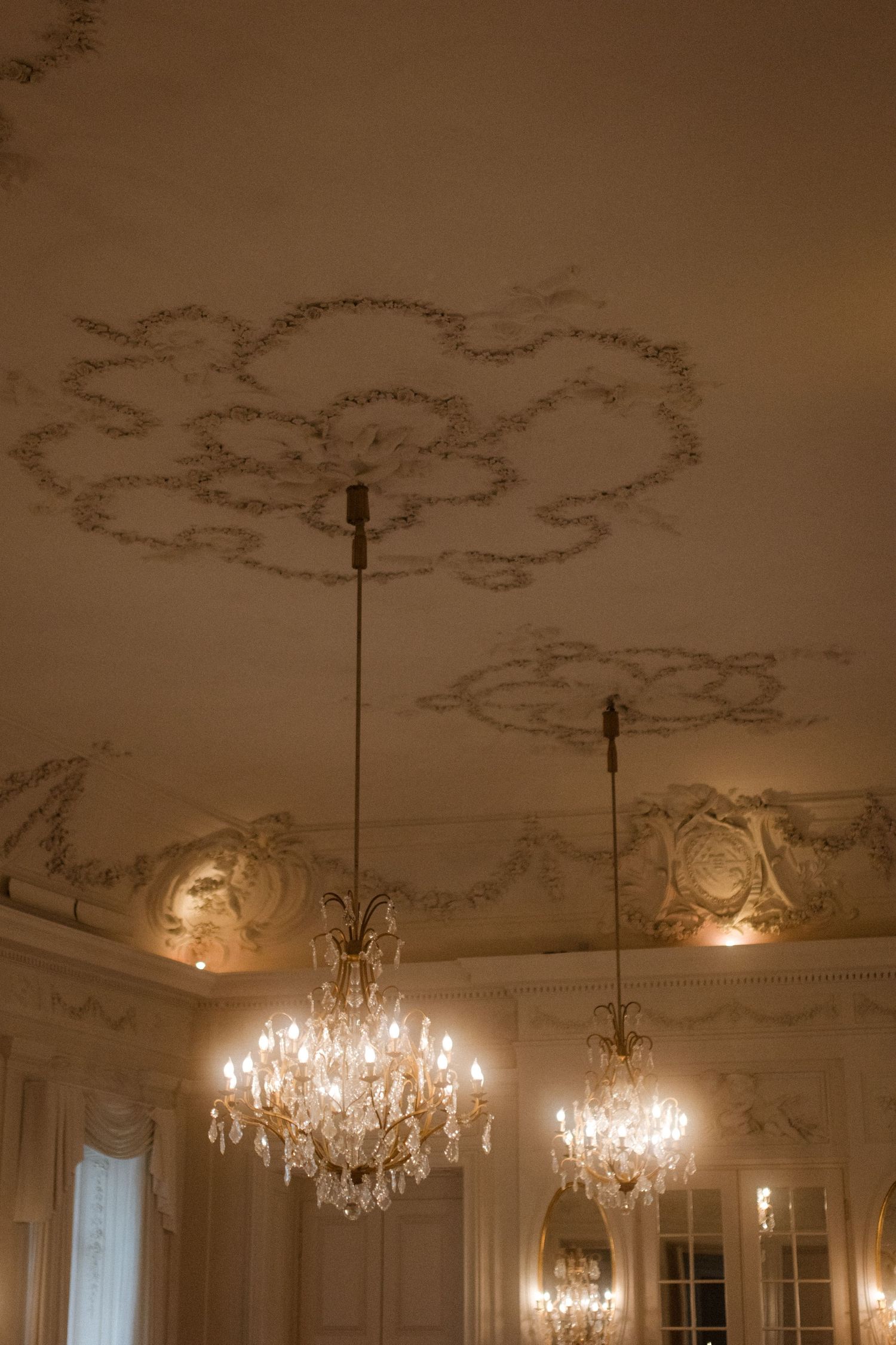 Ornate ceiling with crystal chandeliers and decorative moldings in a grand ballroom.