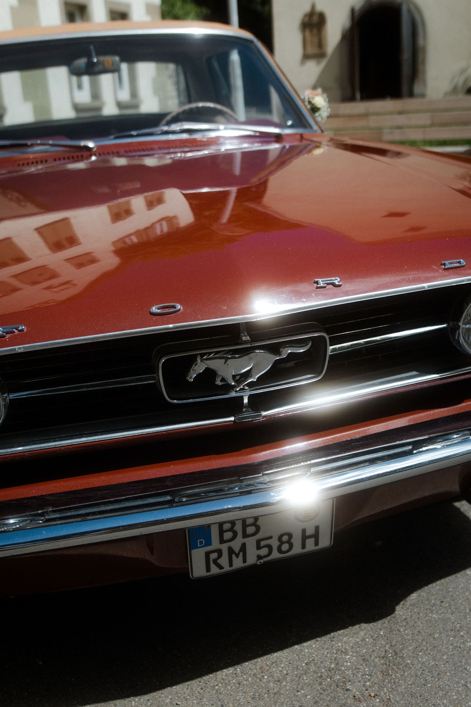 Vintage Ford Mustang front grille and running horse emblem in copper metallic finish.
