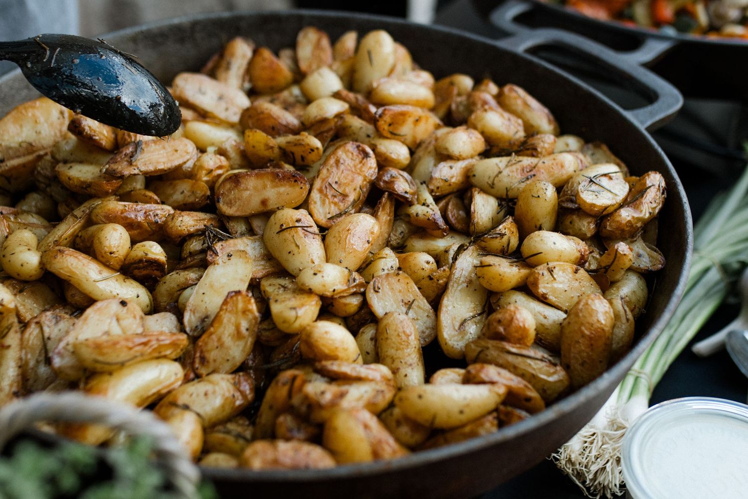 Close-up of sauteed mushrooms in cast iron pan at catering station.