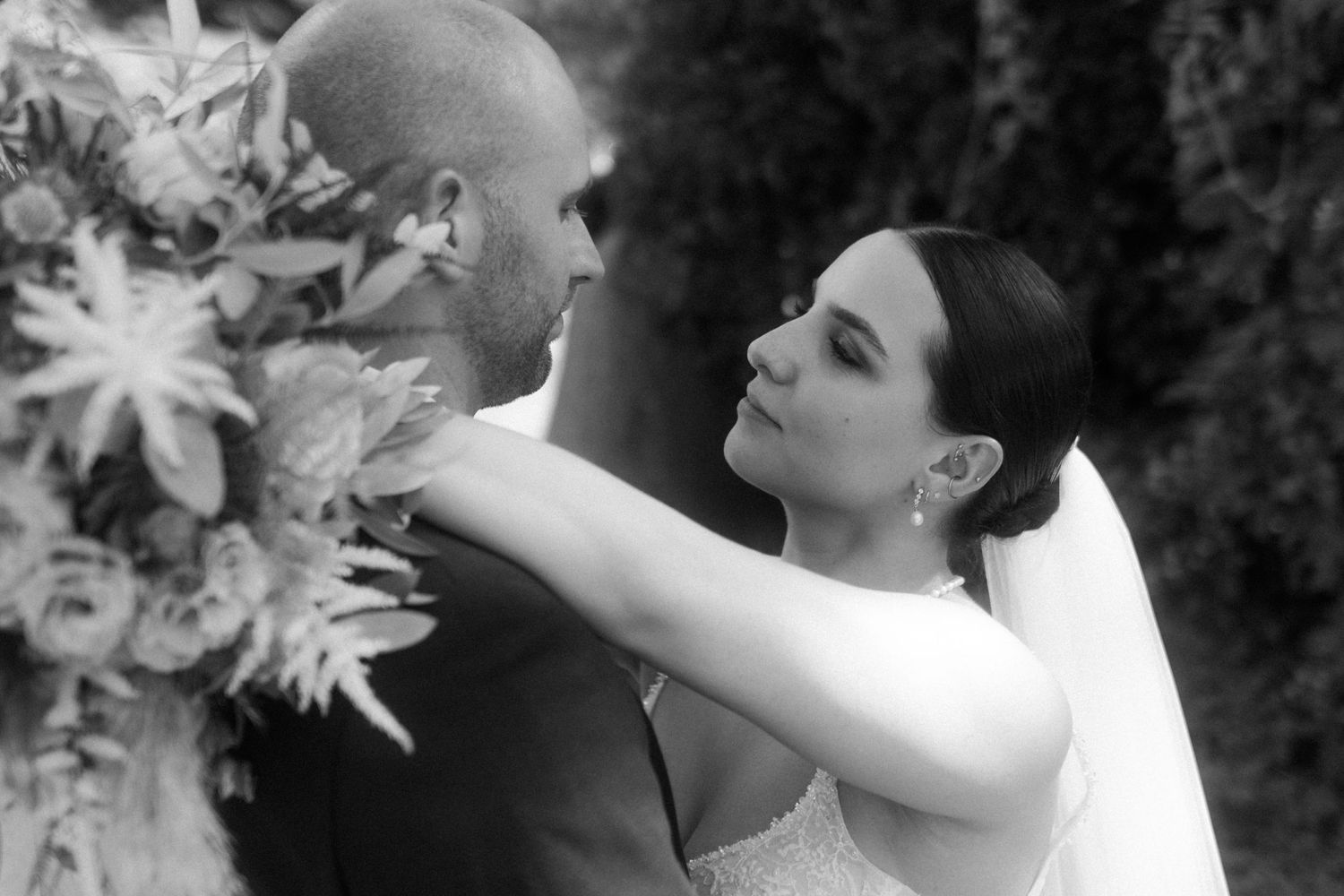 A black and white photo of a romantic wedding moment with floral decorations.