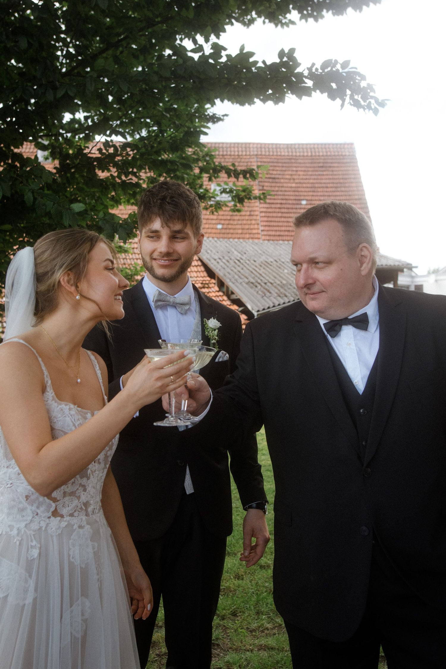 Outdoor wedding celebration with guests enjoying champagne near brick building.