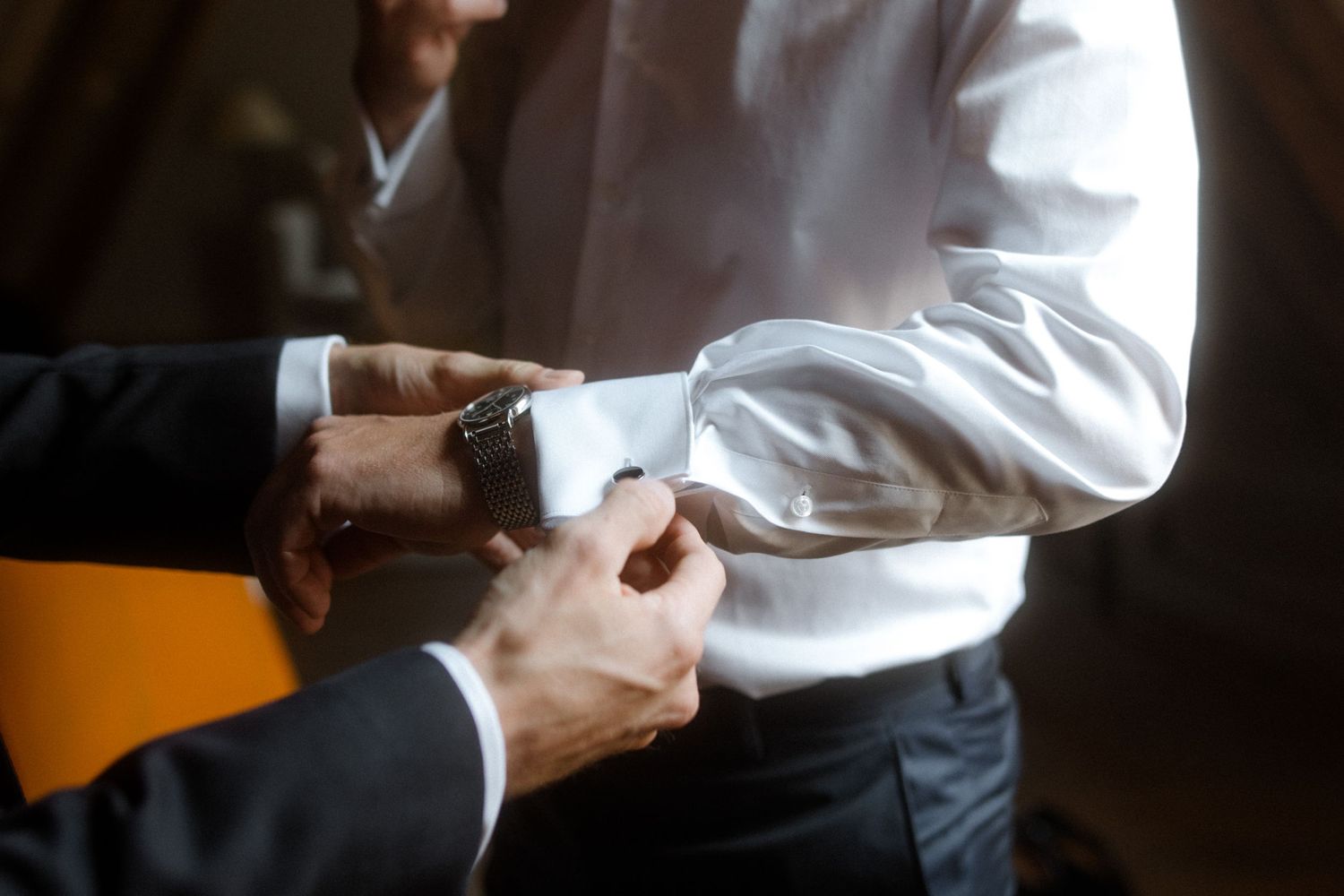 Close up of hands adjusting formal shirt cuffs.