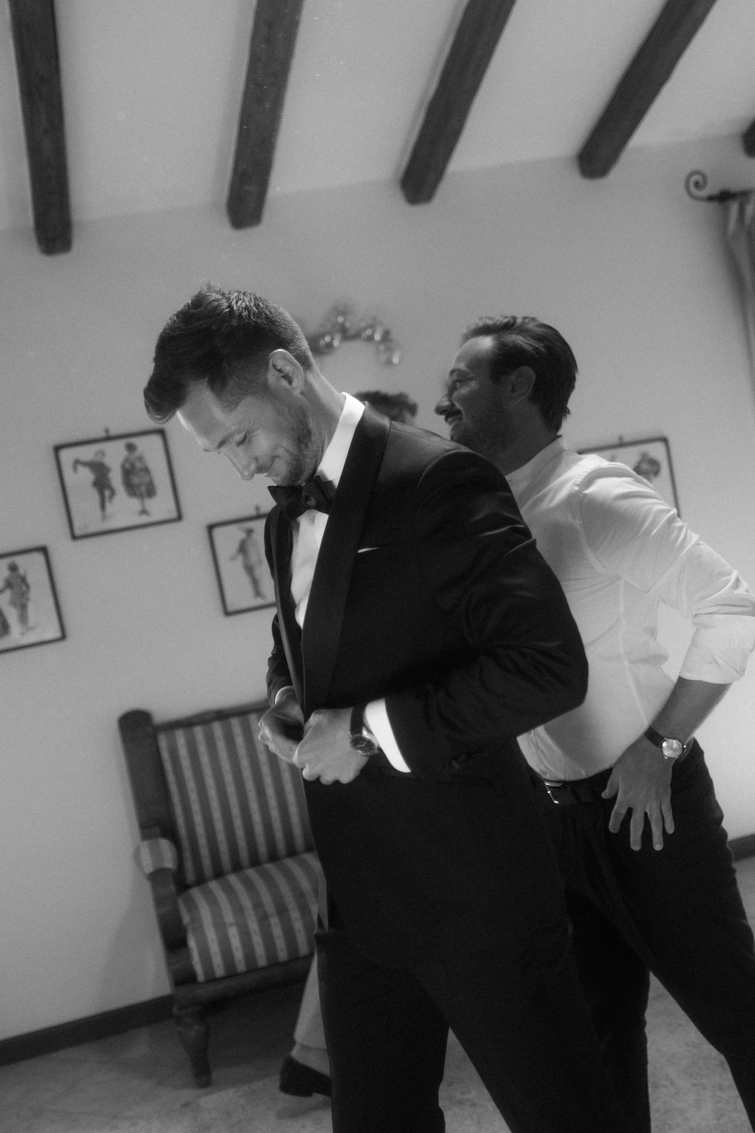 Two people in formal wear interact dramatically in a room with wooden ceiling beams.