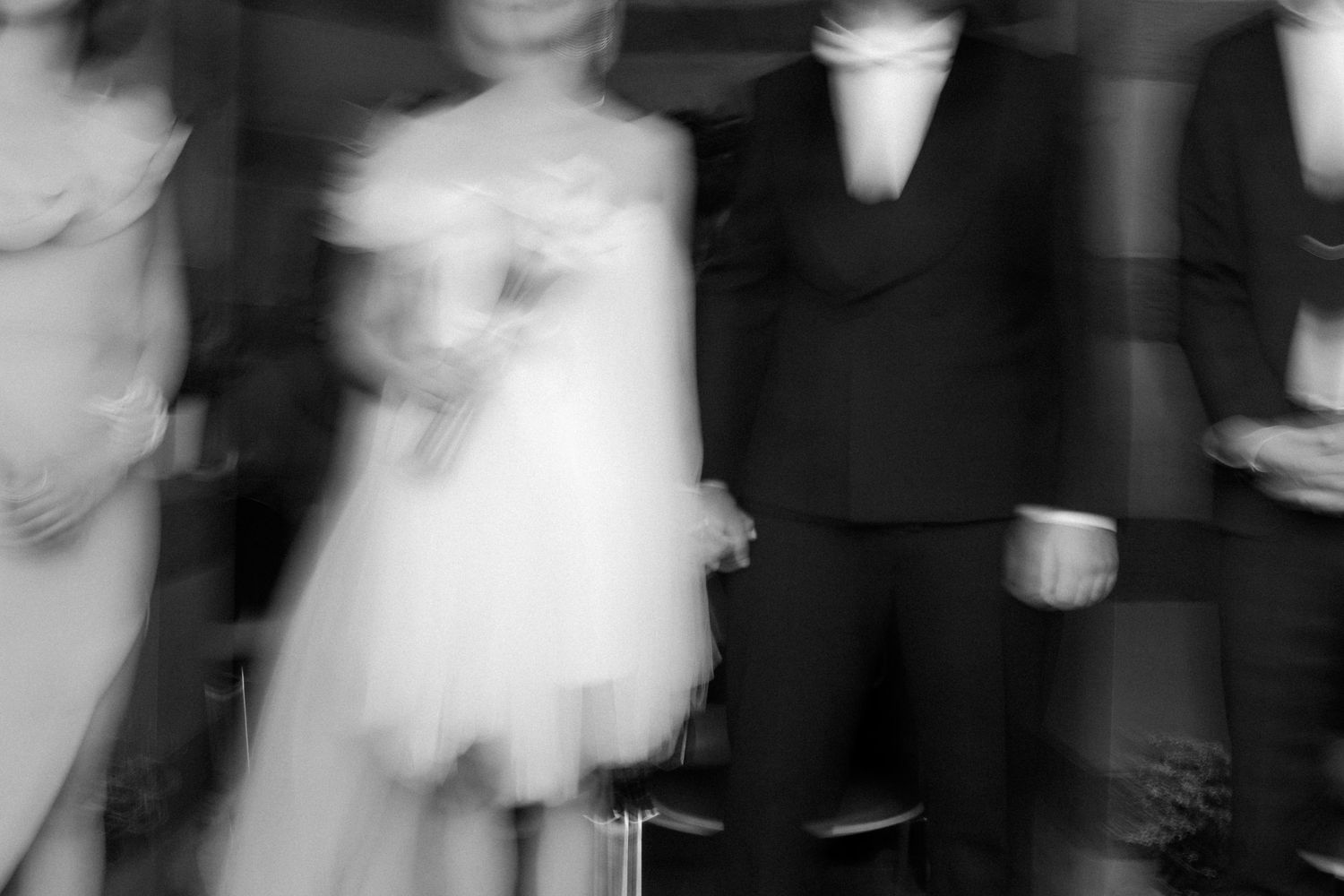 An artistic motion blur photograph of formal wedding attire in black and white.