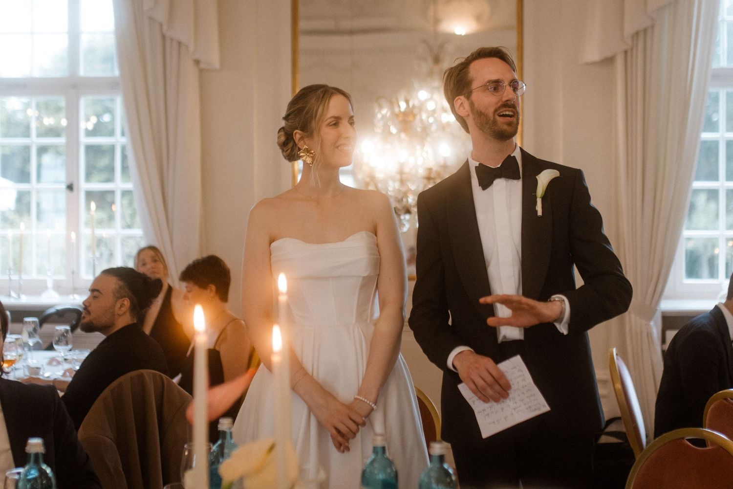 Elegant wedding reception in a grand ballroom with crystal chandeliers and formal attire.