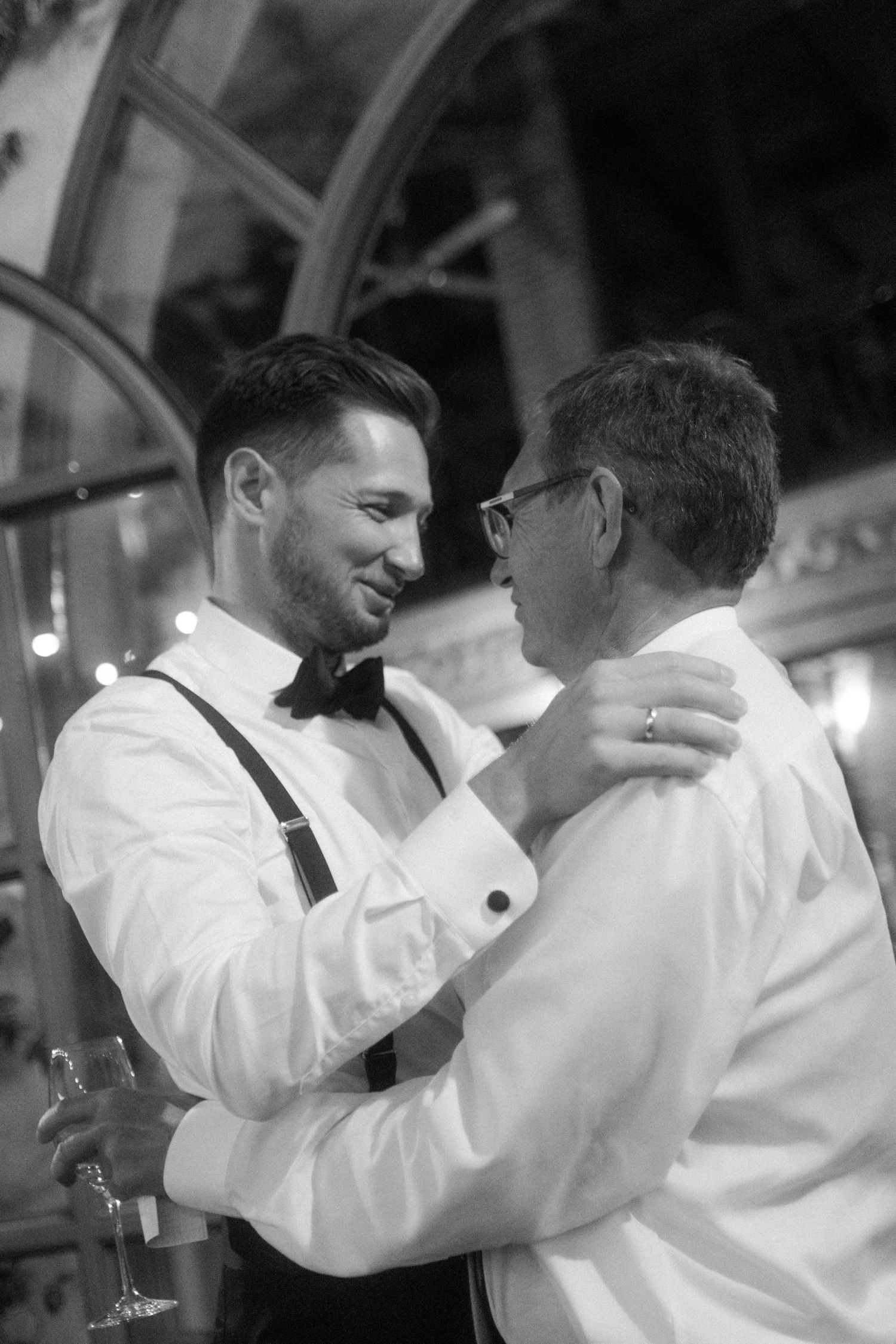 Guests sharing embraces during an emotional wedding celebration.