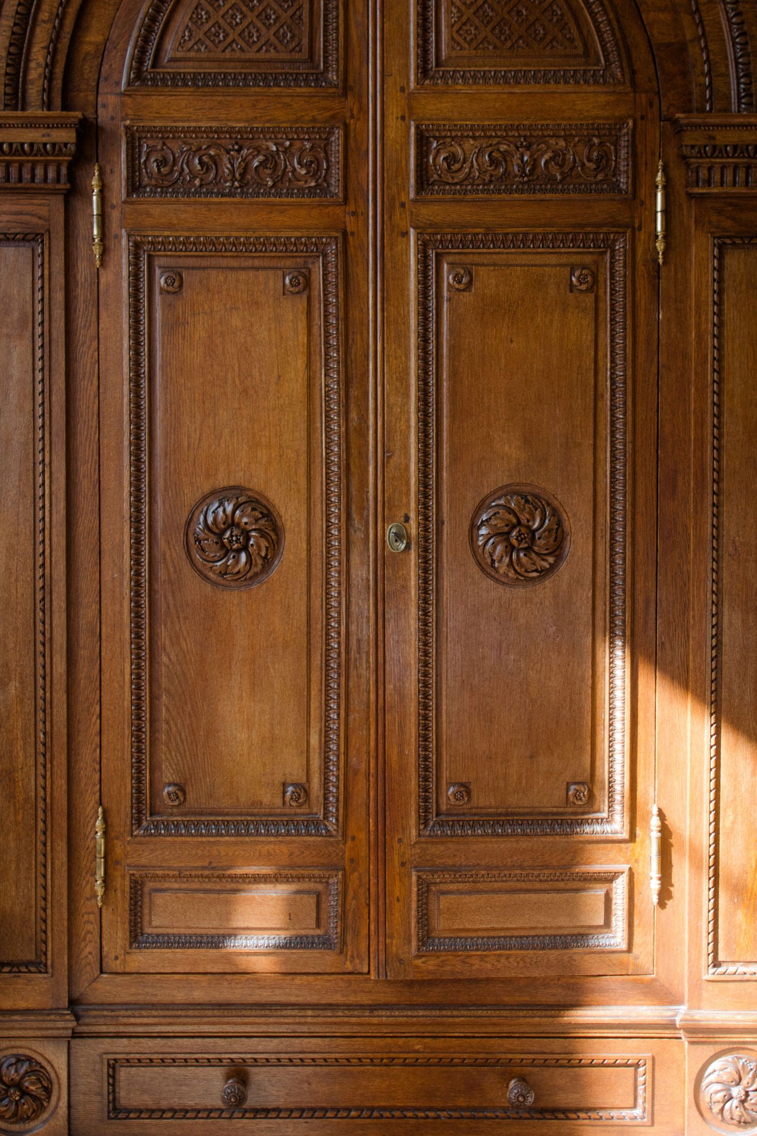 Ornate wooden paneling with detailed carvings and decorative moldings in a traditional interior.