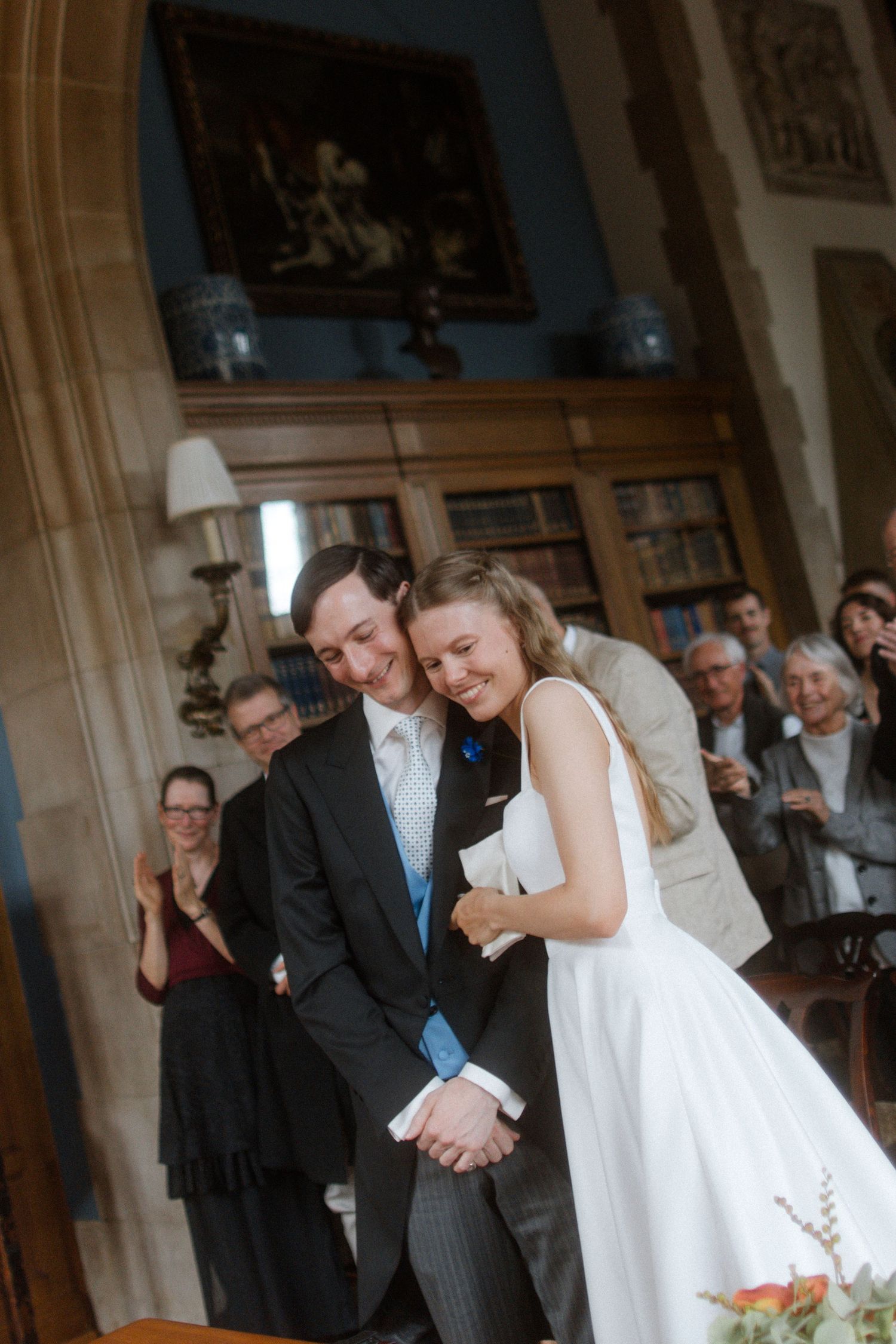 Newlyweds sharing a romantic dance moment in an ornate room with wood paneling.