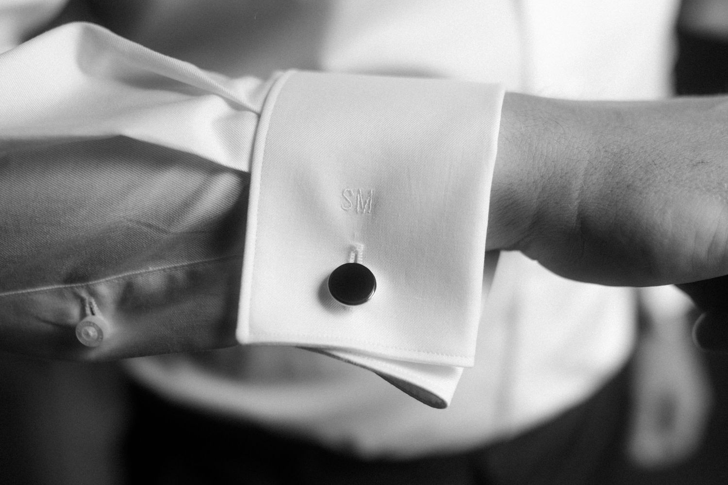 Detailed shot of a formal white shirt cuff with cufflink.