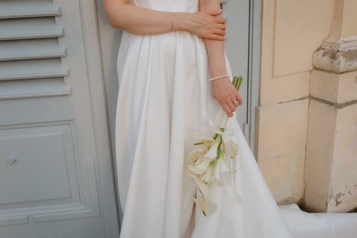 A close-up detail shot of a white calla lily boutonniere pinned to a black tuxedo lapel.