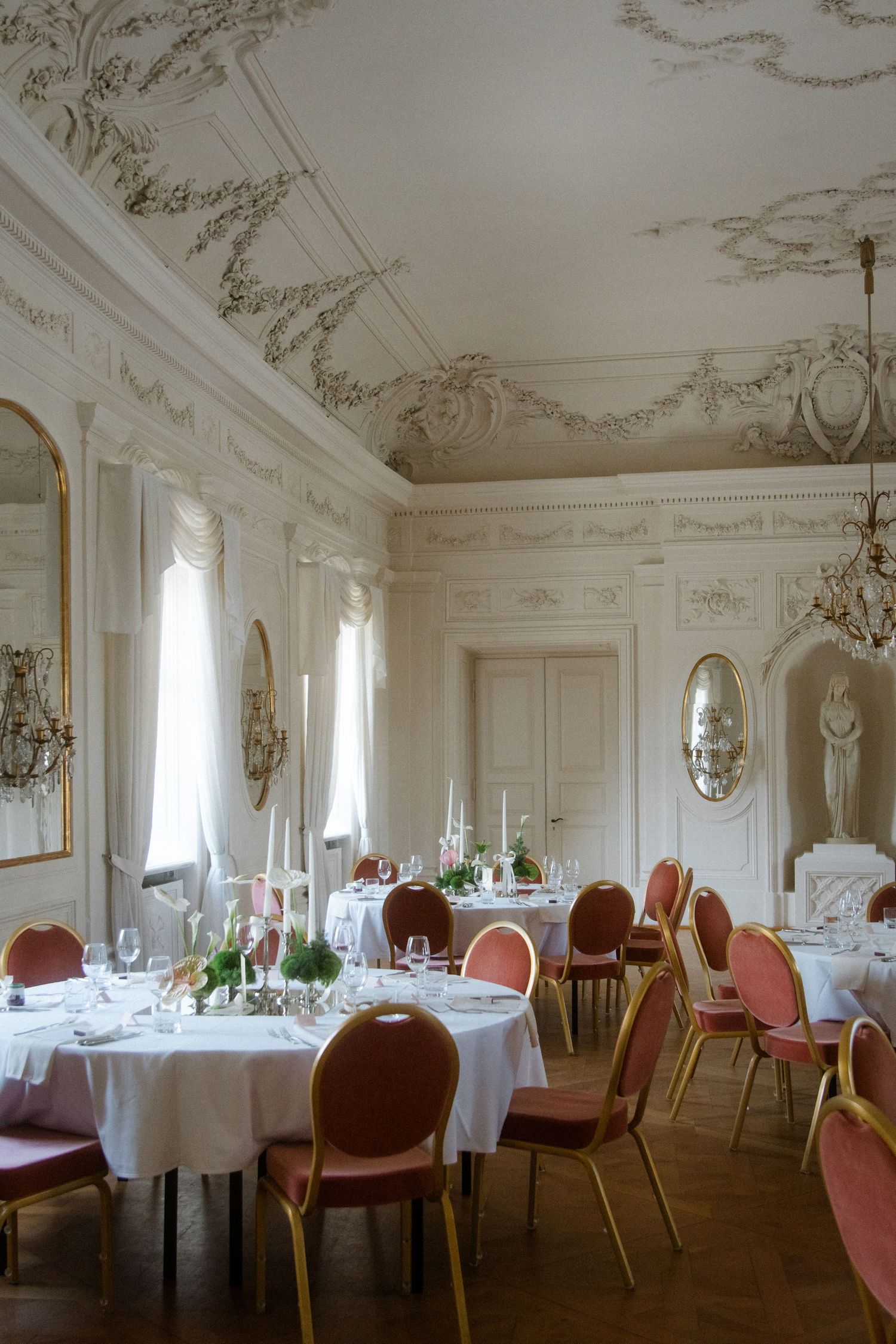 Classic wedding venue interior featuring ornate moldings and red velvet chairs.