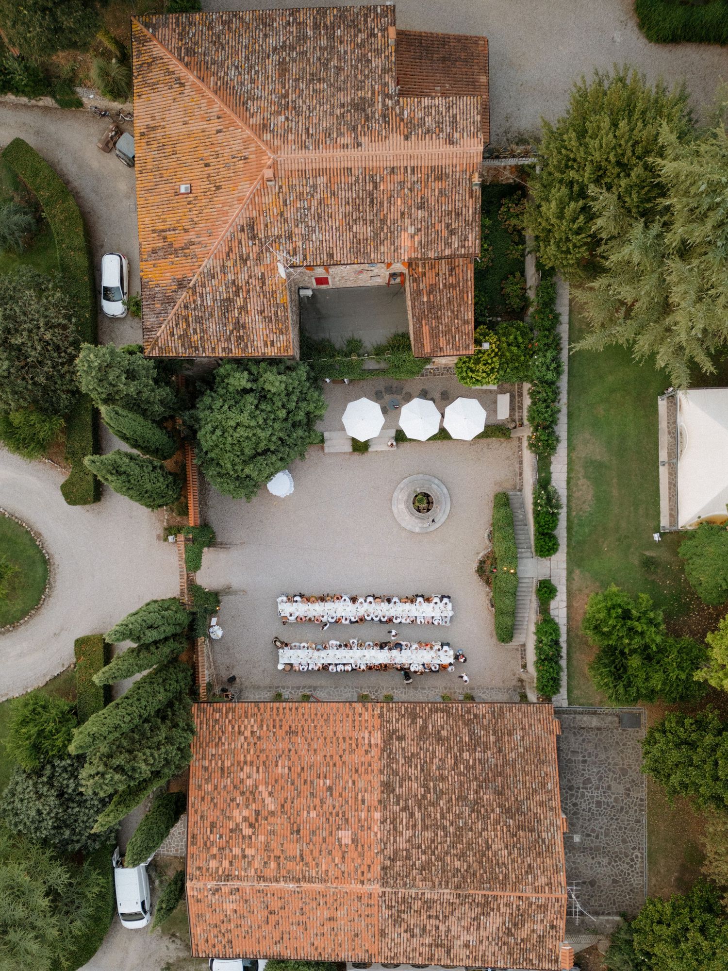 Aerial view of a rustic venue with terracotta roofs and outdoor dining setup.