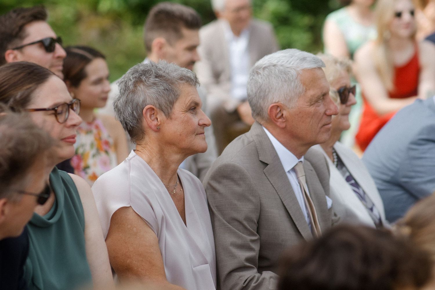 Wedding guests seated outdoors watching the ceremony.