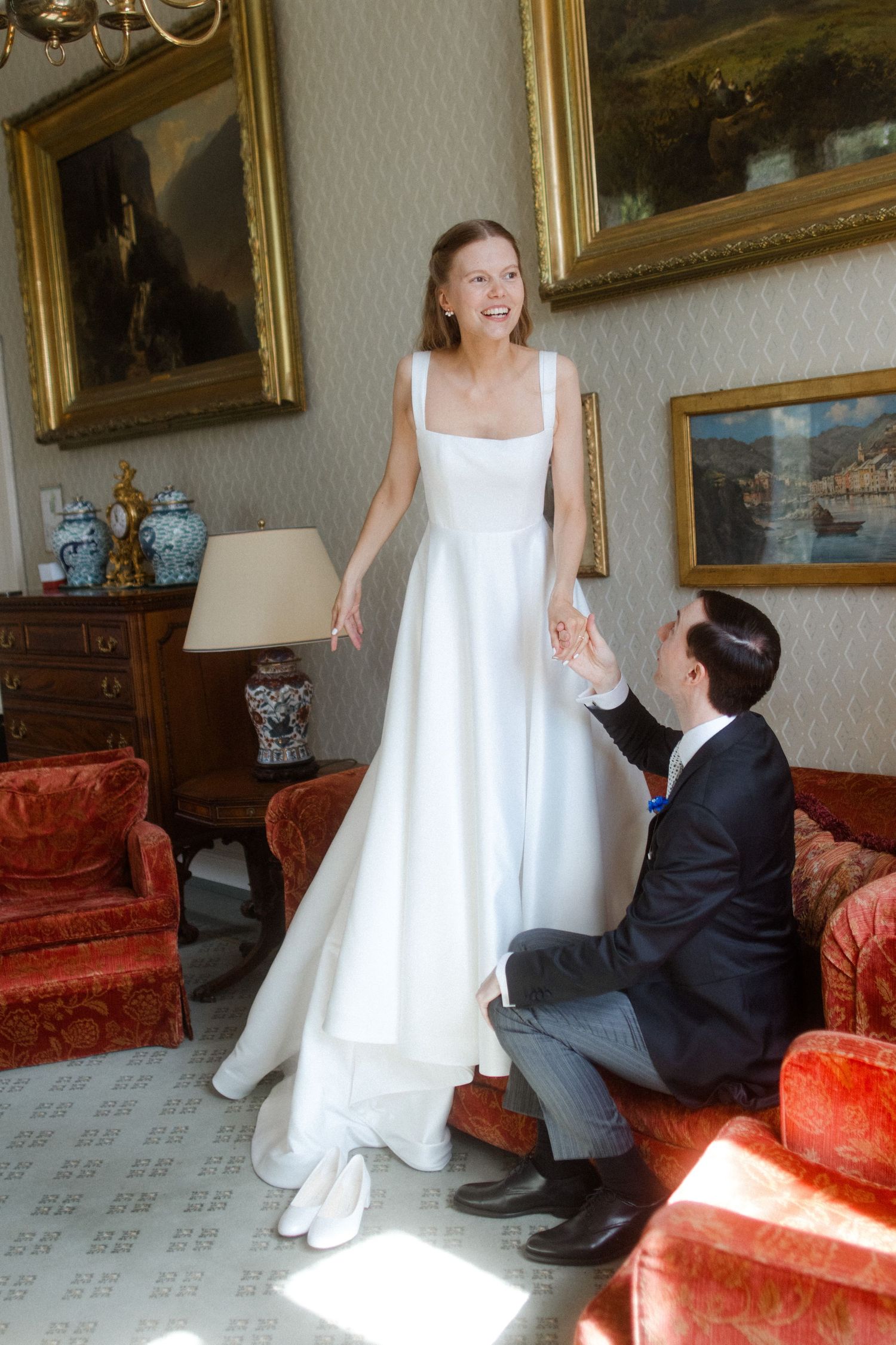 Wedding photo sequence in an elegant room with gold-framed paintings and red furniture.