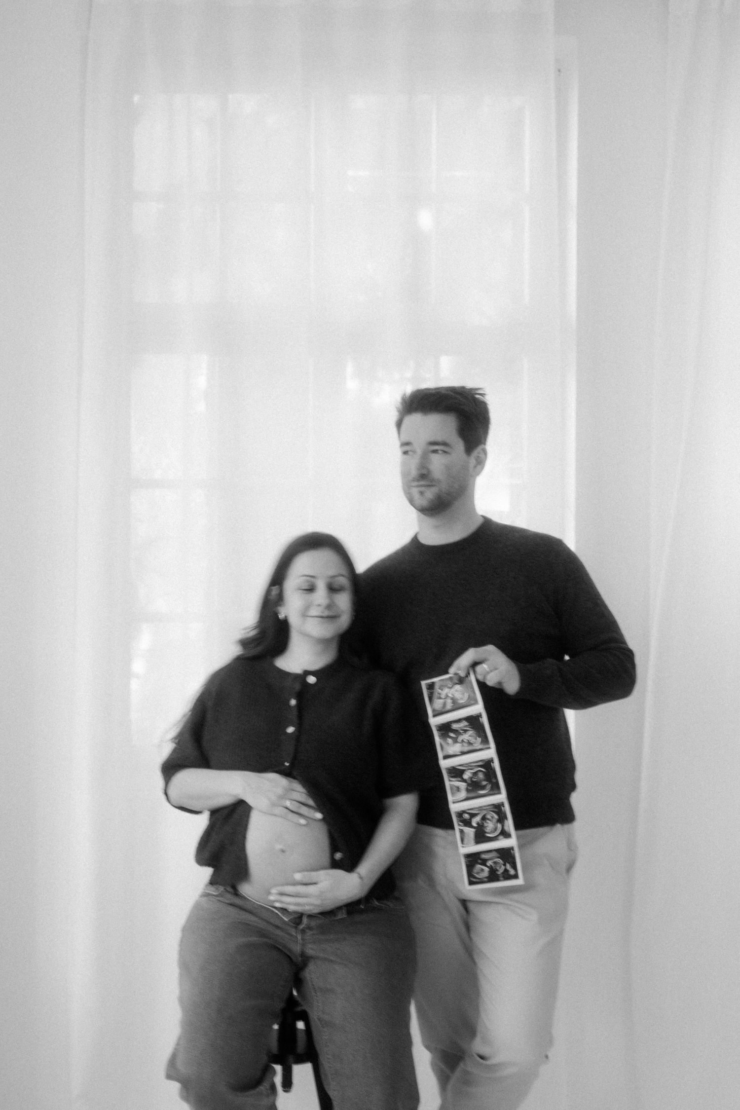 A black and white photo sequence showing a couple's pregnancy progression through four stages.