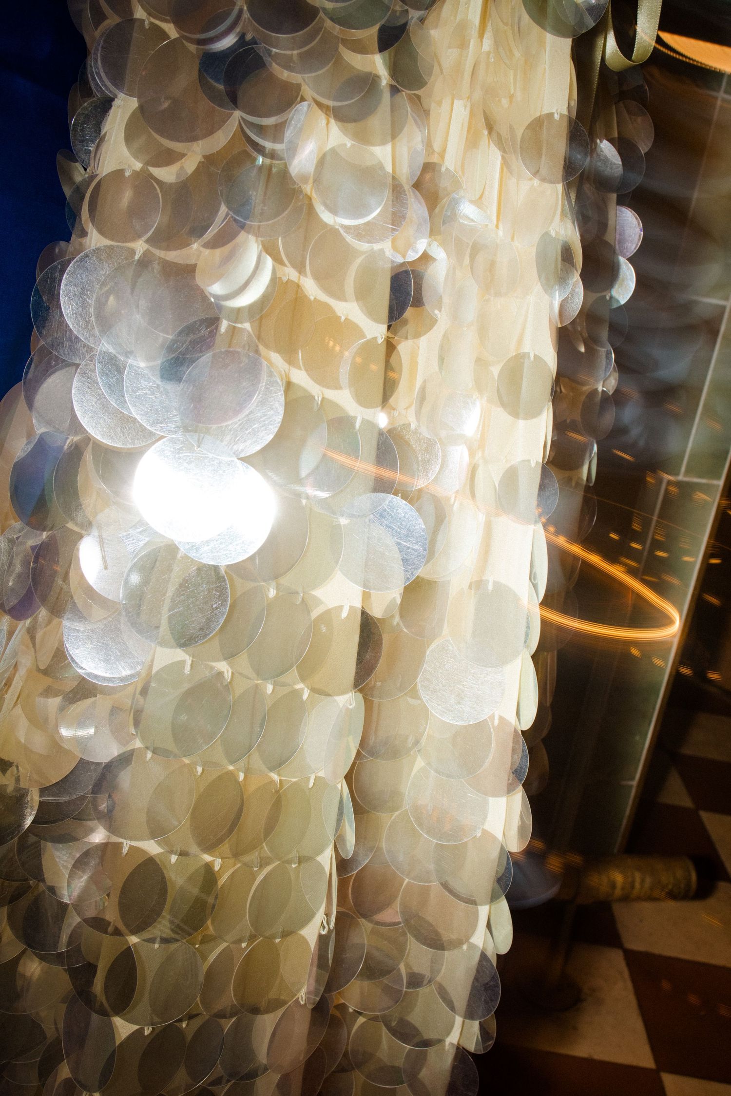 A luminous capiz shell chandelier with overlapping circular discs glowing warmly in soft ambient light.