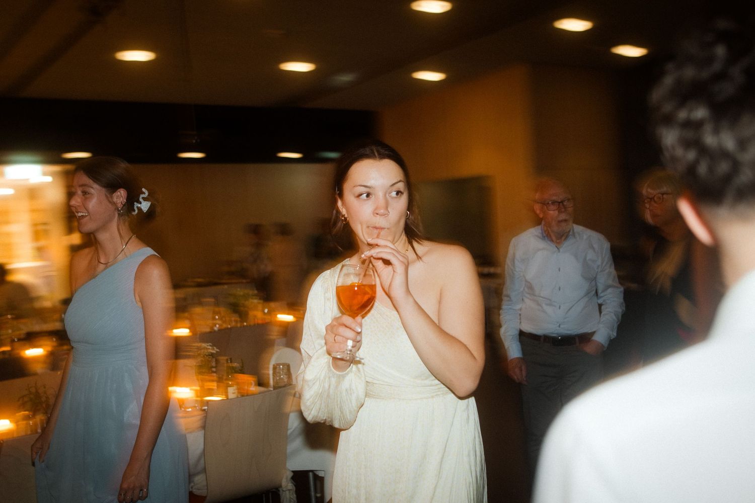 Candid celebration moment at an indoor reception with warm ambient lighting.