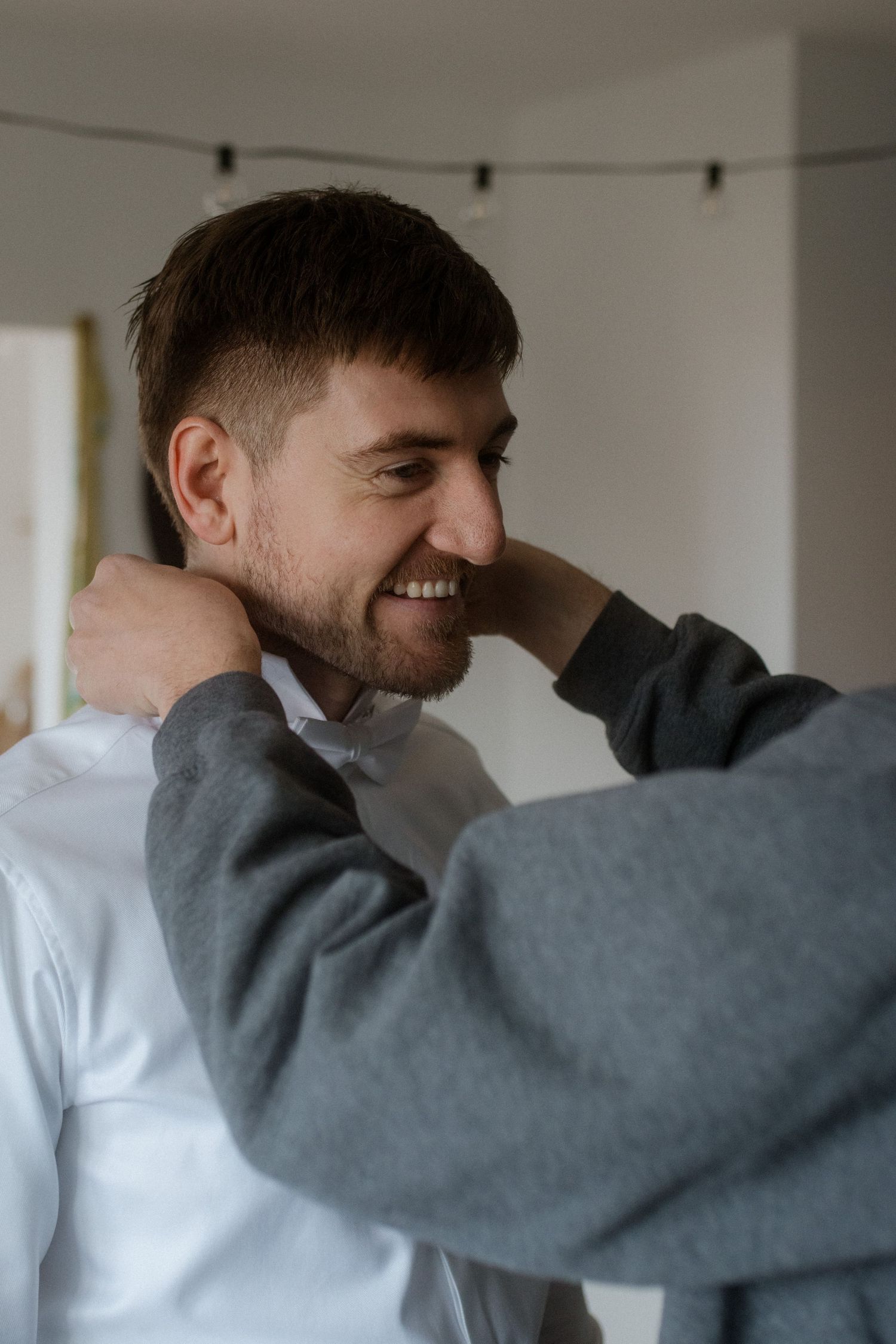 A heartfelt moment between two people during formal dress preparation.