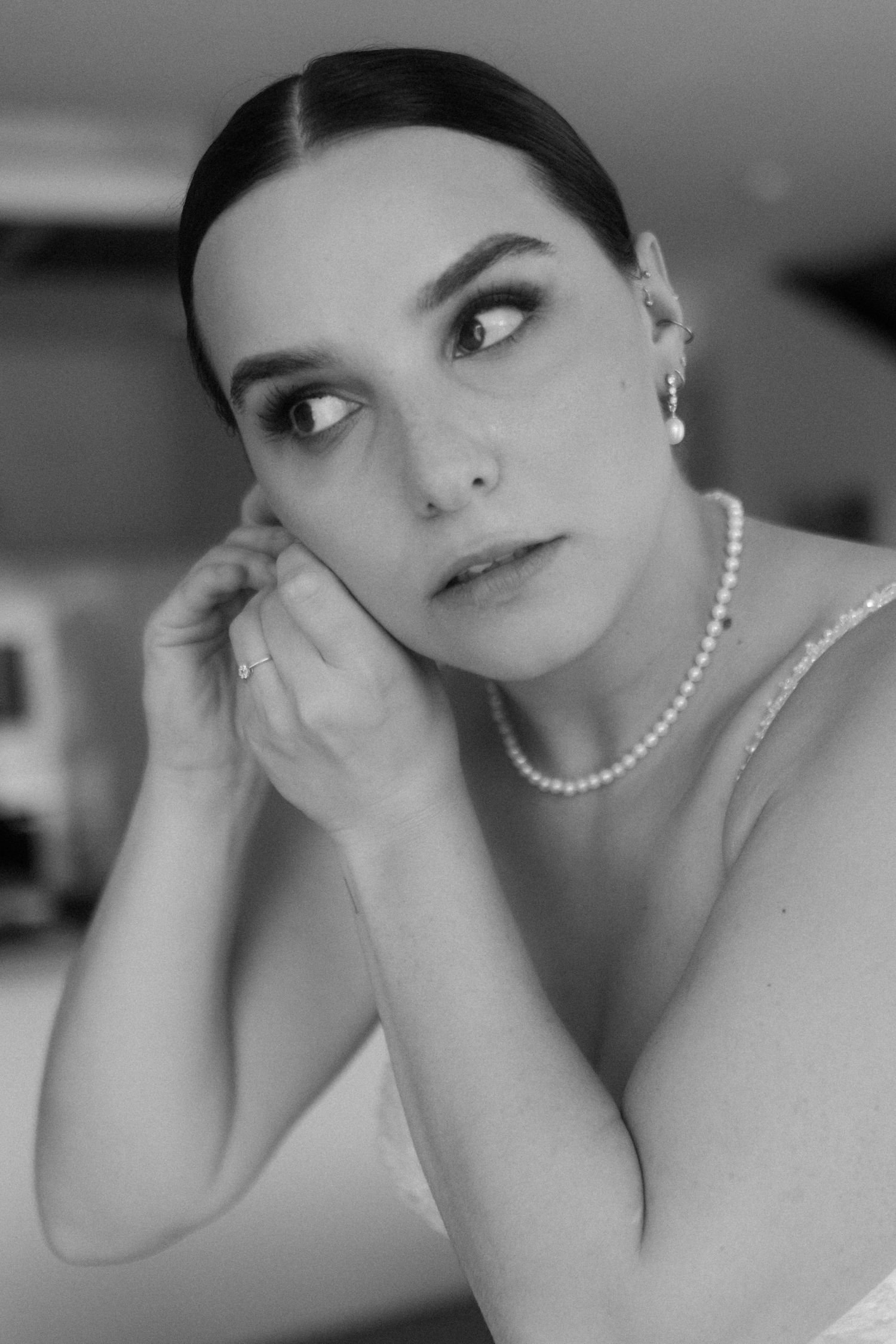 Artistic black and white portrait series showing elegant pearl necklace and formal attire.