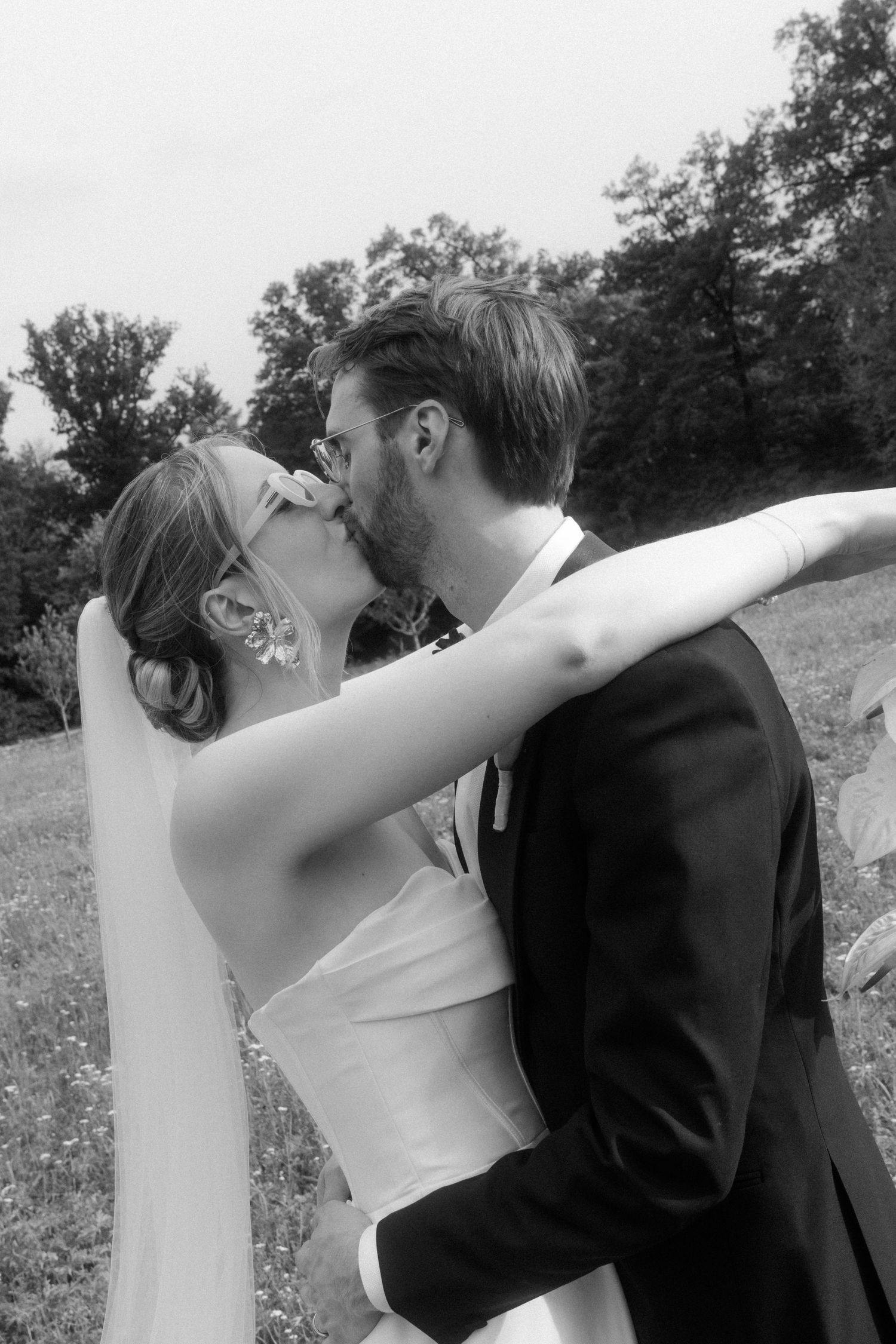 Artistic black and white sequence captures tender moments between newlyweds in a field.