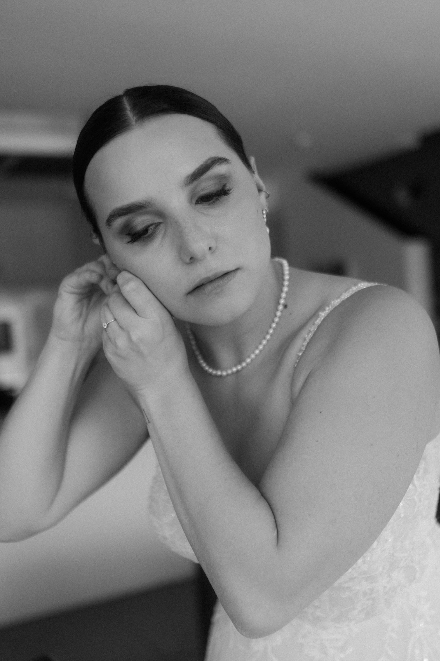 Black and white portrait showing pearl necklace and elegant bridal makeup.