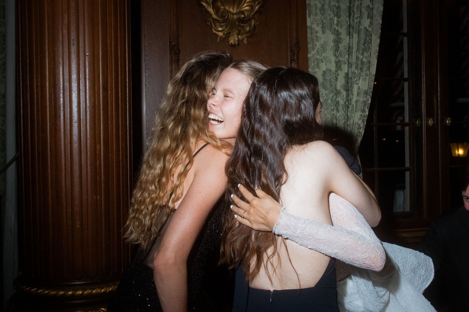 Wedding celebration moment captured in wood-paneled reception venue.