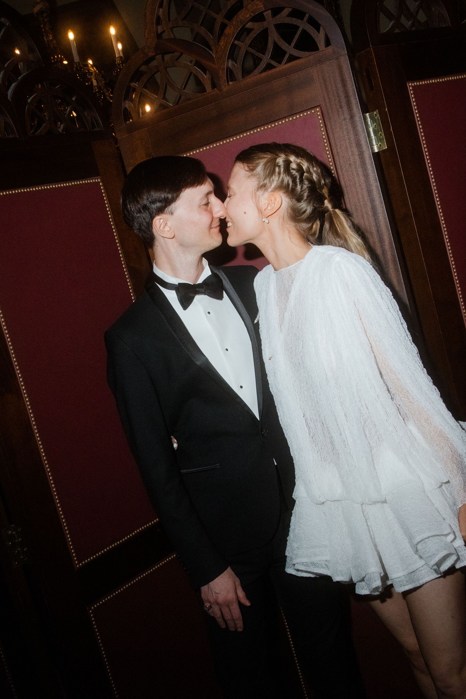 Romantic couple in formal wear sharing an intimate moment in an elegant venue.