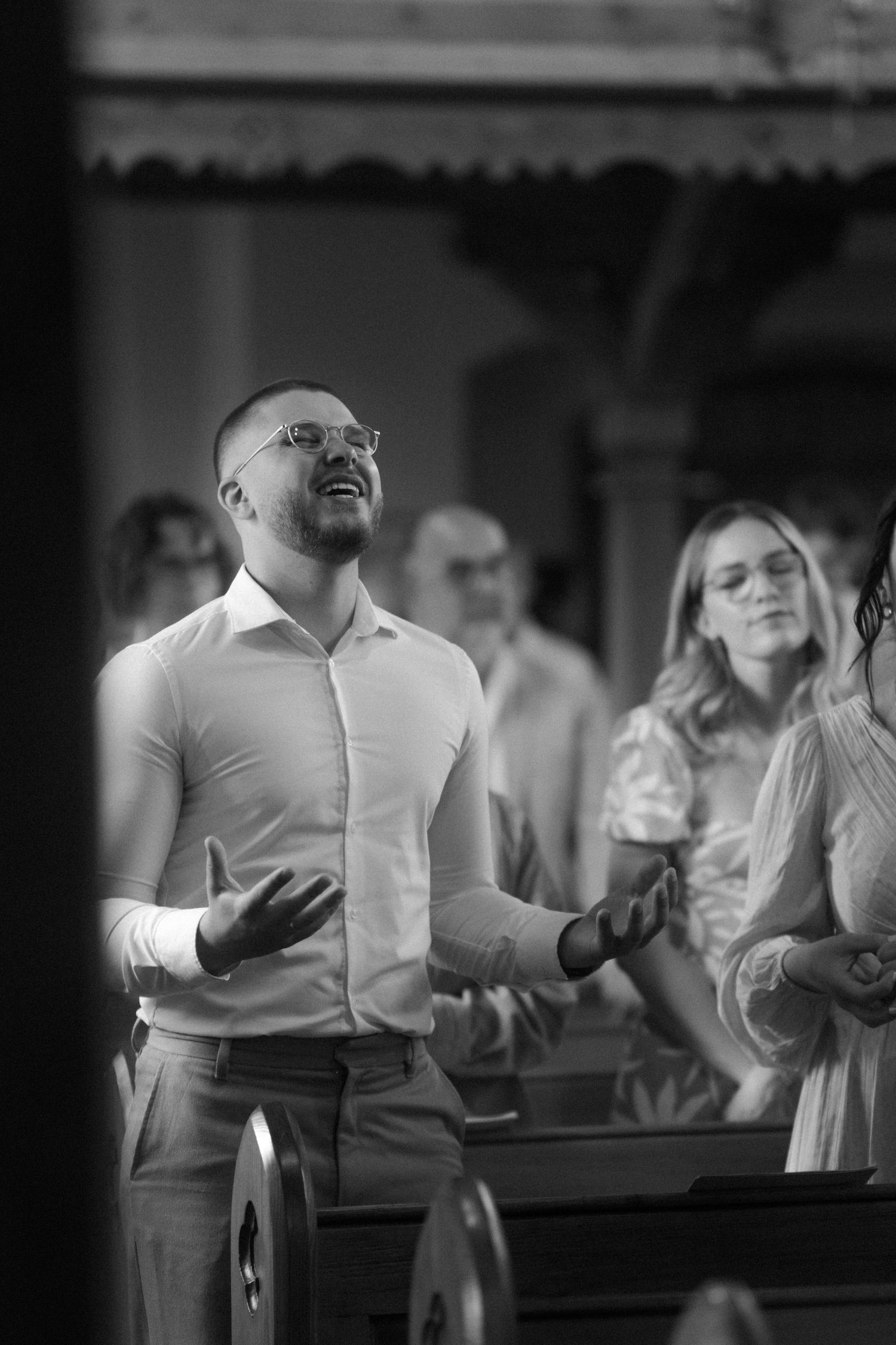 A black and white photo of people singing during a church service.