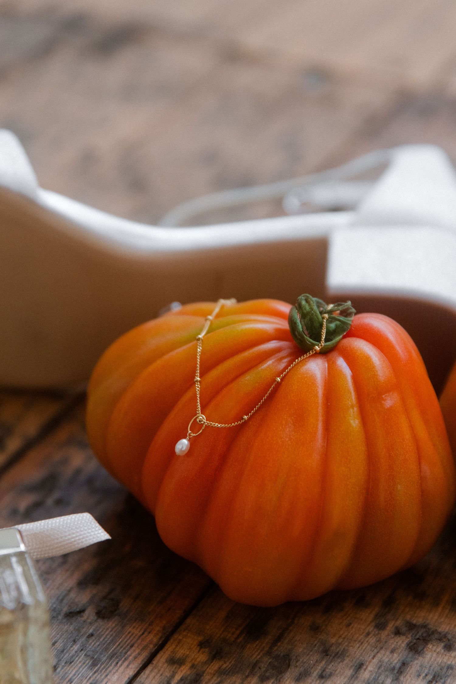 Orange heirloom pumpkin with pins marking placement details on rustic wooden surface.