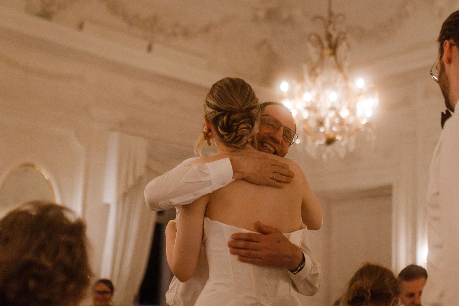 Couples embracing during a romantic moment at an elegant ballroom wedding reception.